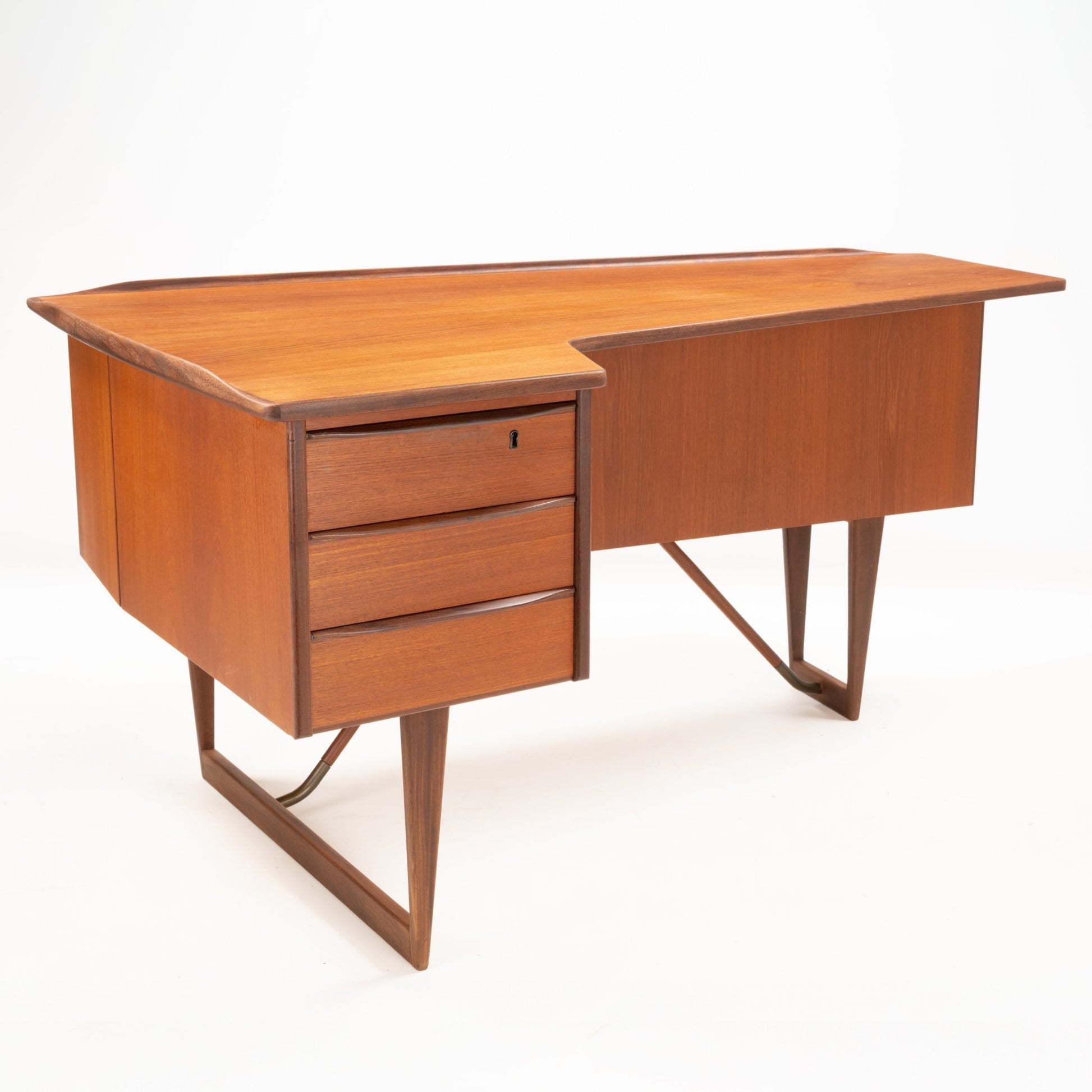 1960s Danish teak desk with signature asymmetrical boomerang-shaped top and three drawers on angled legs