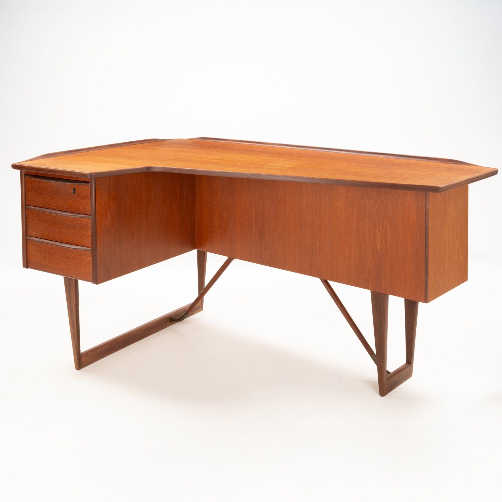 1960s Danish teak writing desk with L-shaped sculptural top, three drawers, and geometric open leg frame by Peter Løvig Nielsen