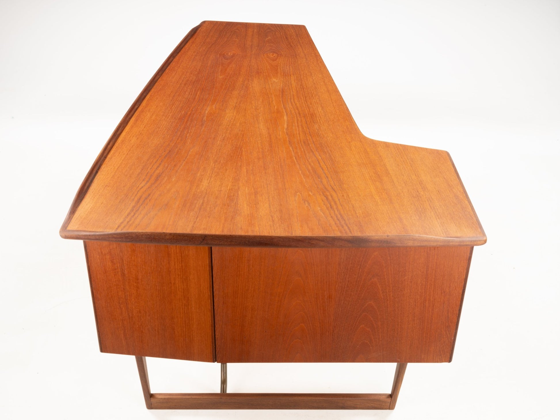 1960s Danish teak writing desk with oversized asymmetrical boomerang-shaped top and wooden cabinet base