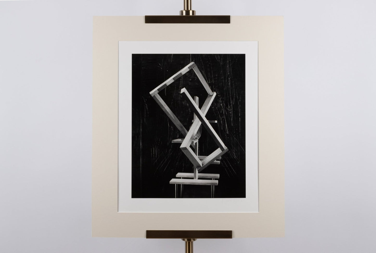 Black and white photograph of abstract geometric shapes with hand manipulation, matted and signed, dated 1991.