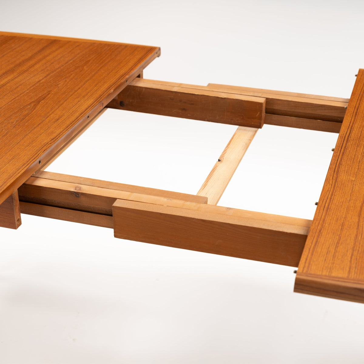 Rastad & Relling Extension Dining Table showing exposed wooden extension rails and separated teak leaves in mid century modern furniture style