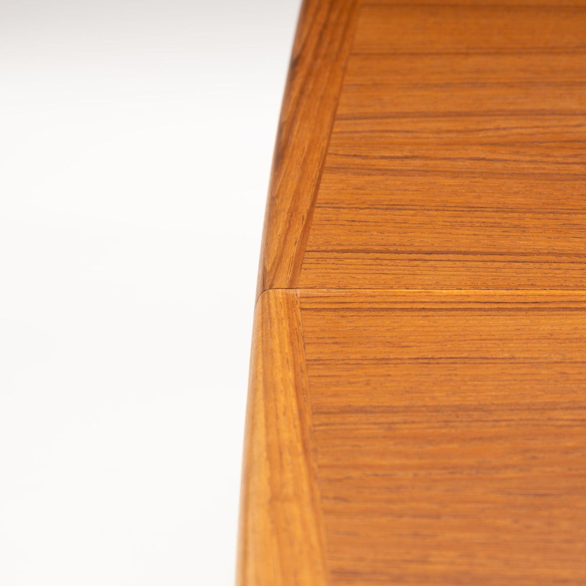 Rastad & Relling Extension Dining Table close up showing the warm teak tabletop corner and visible leaf joint with fine grain in mid century modern furniture style