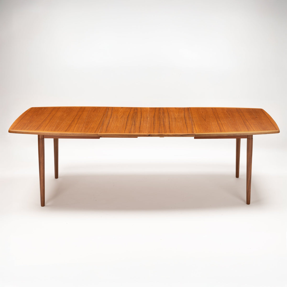 Rastad & Relling Extension Dining Table in warm teak with rounded rectangular top and tapered legs showcasing mid century modern furniture