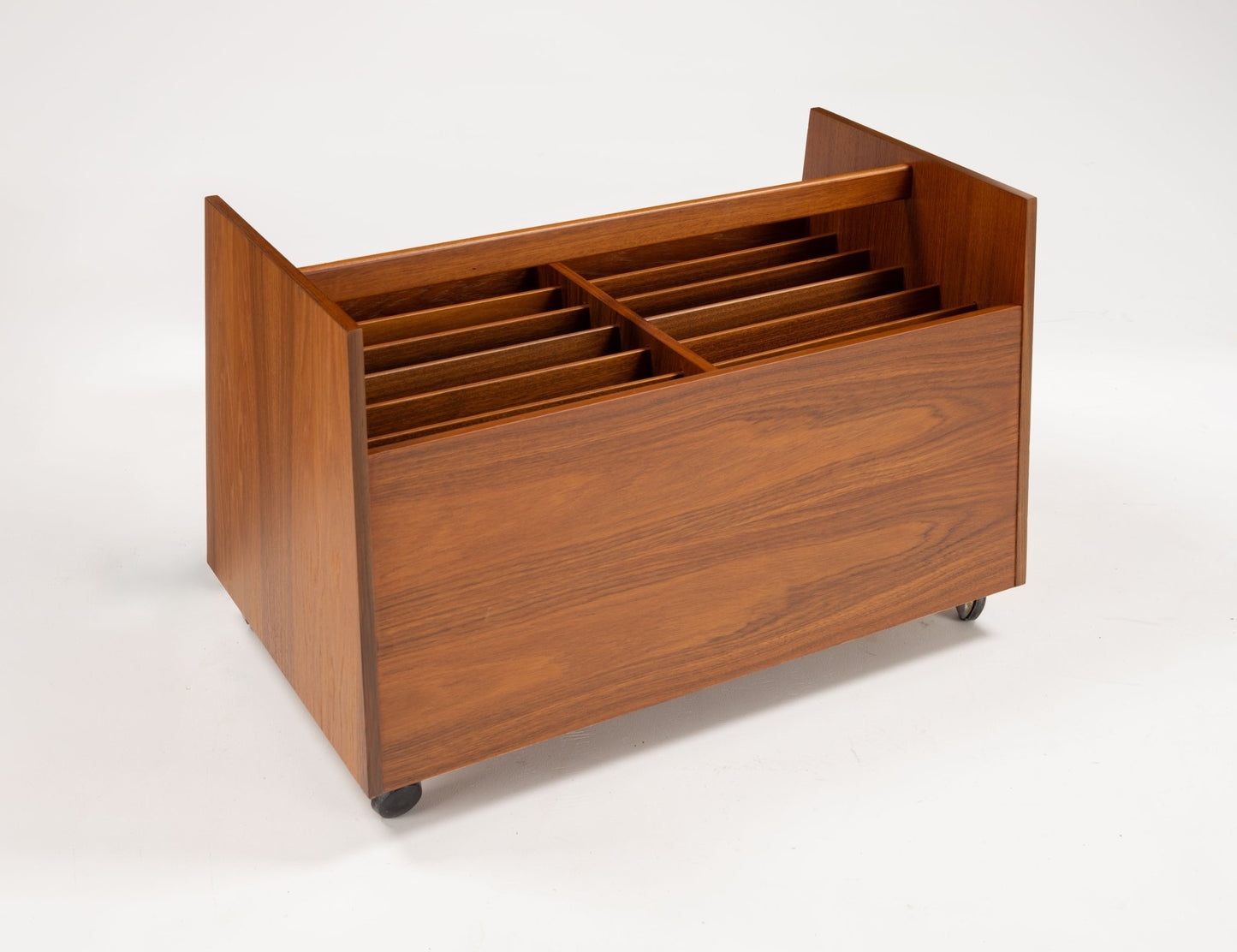 Mid-century modern teak record and magazine caddy with double-wide compartments, internal dividers, handle, and castors.