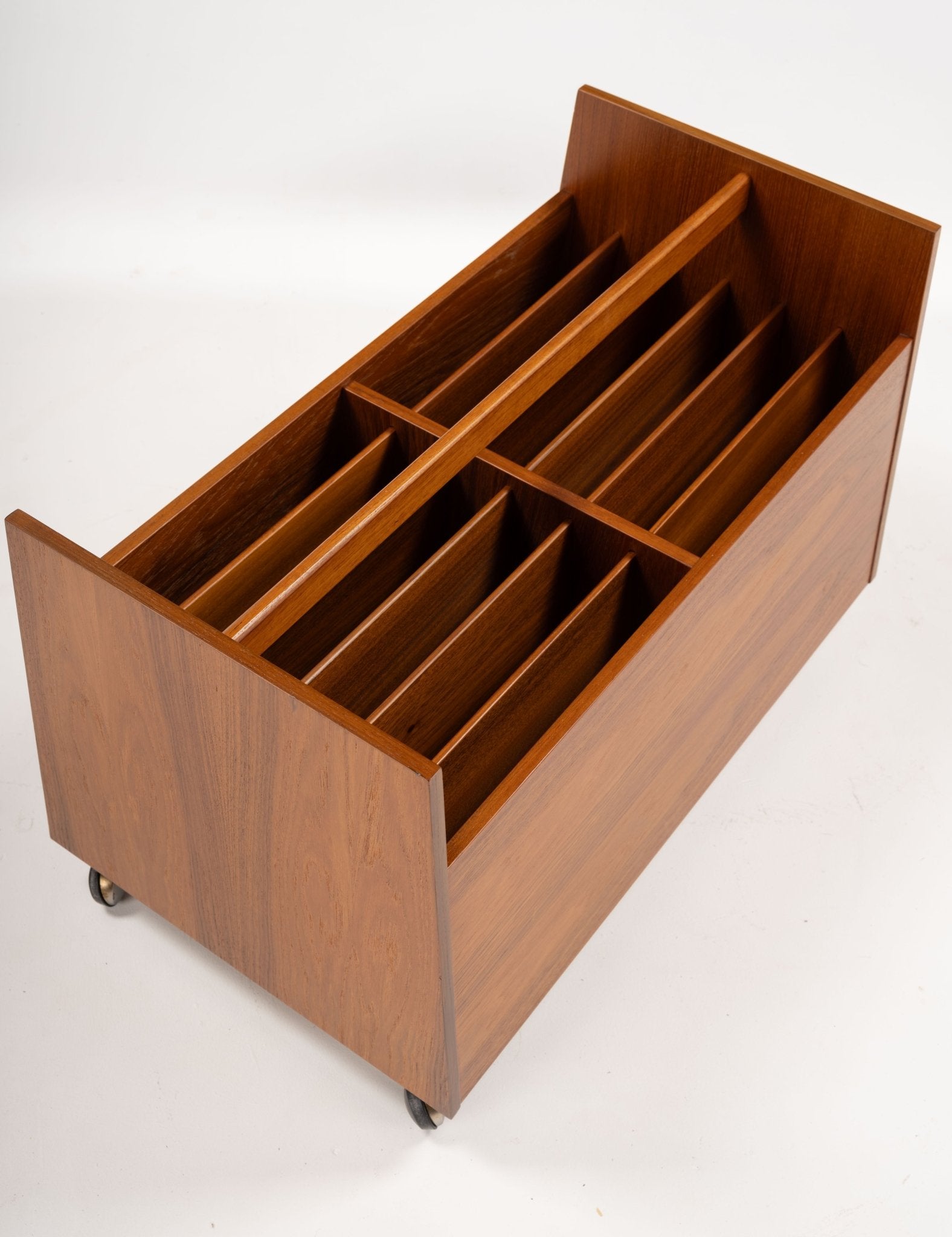 Double-wide mid-century modern teak record and magazine caddy by Rolf Hesland with internal dividers and castors.