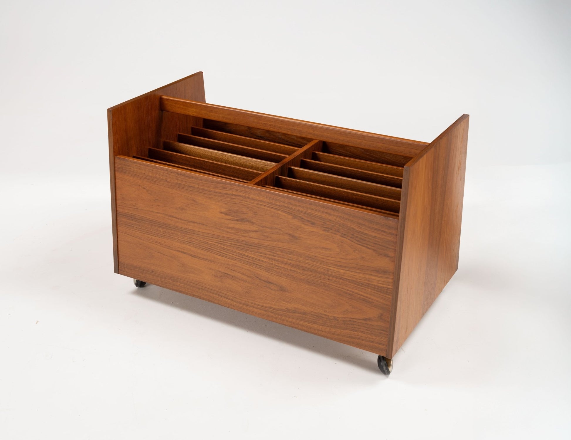 Mid-century modern teak record and magazine caddy with dividers, handle, and castors designed by Rolf Hesland.