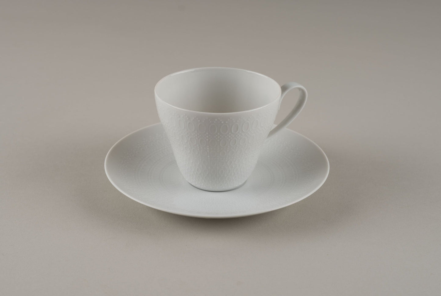 White Rosenthal "Romance" porcelain cup and saucer with an embossed symmetrical pattern by Bjorn Wiinblad.
