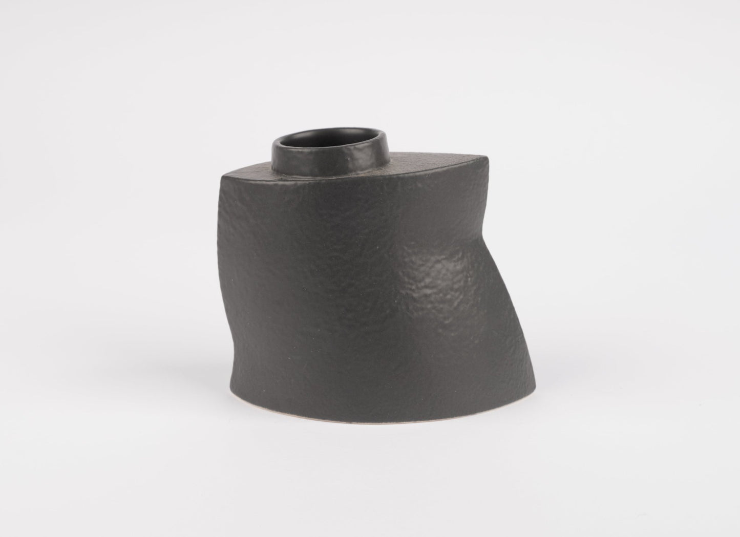 Sculptural black stoneware vase with asymmetrical faceted silhouette and matte charcoal finish on white background