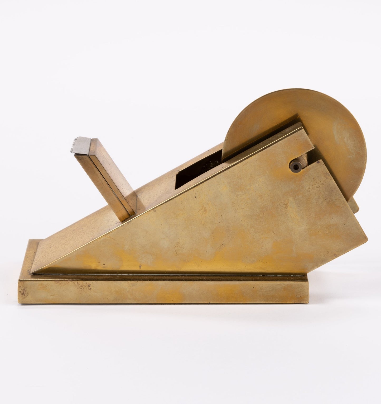 Vintage sculptural solid brass tape dispenser with minimalist angular form and integrated blade on white background