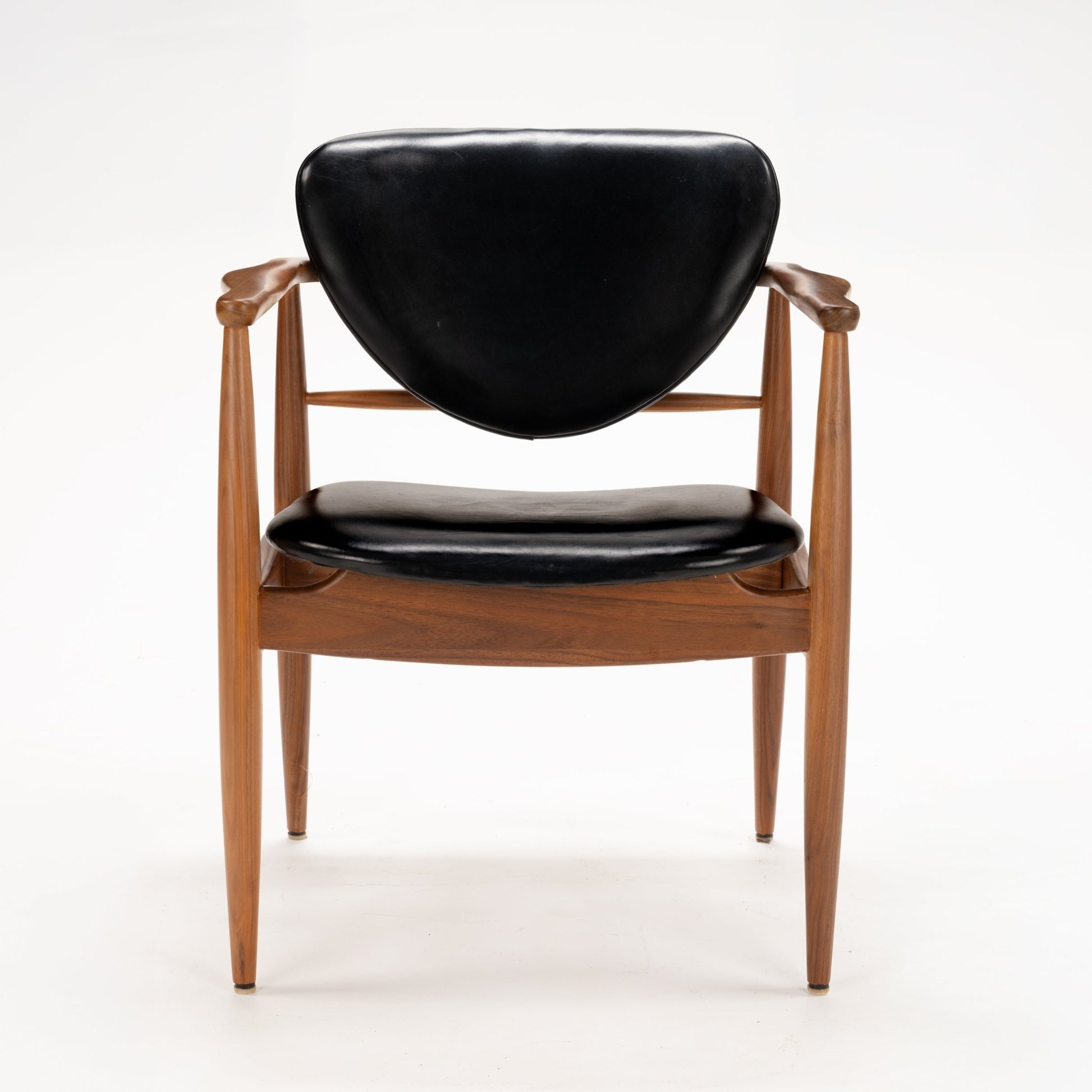 Set of 4 Walnut Dining Armchairs Attributed to Finn Juhl featuring sculpted walnut frames with gently curved arms and black leather upholstered seats and backs, reflecting mid century modern seating design.