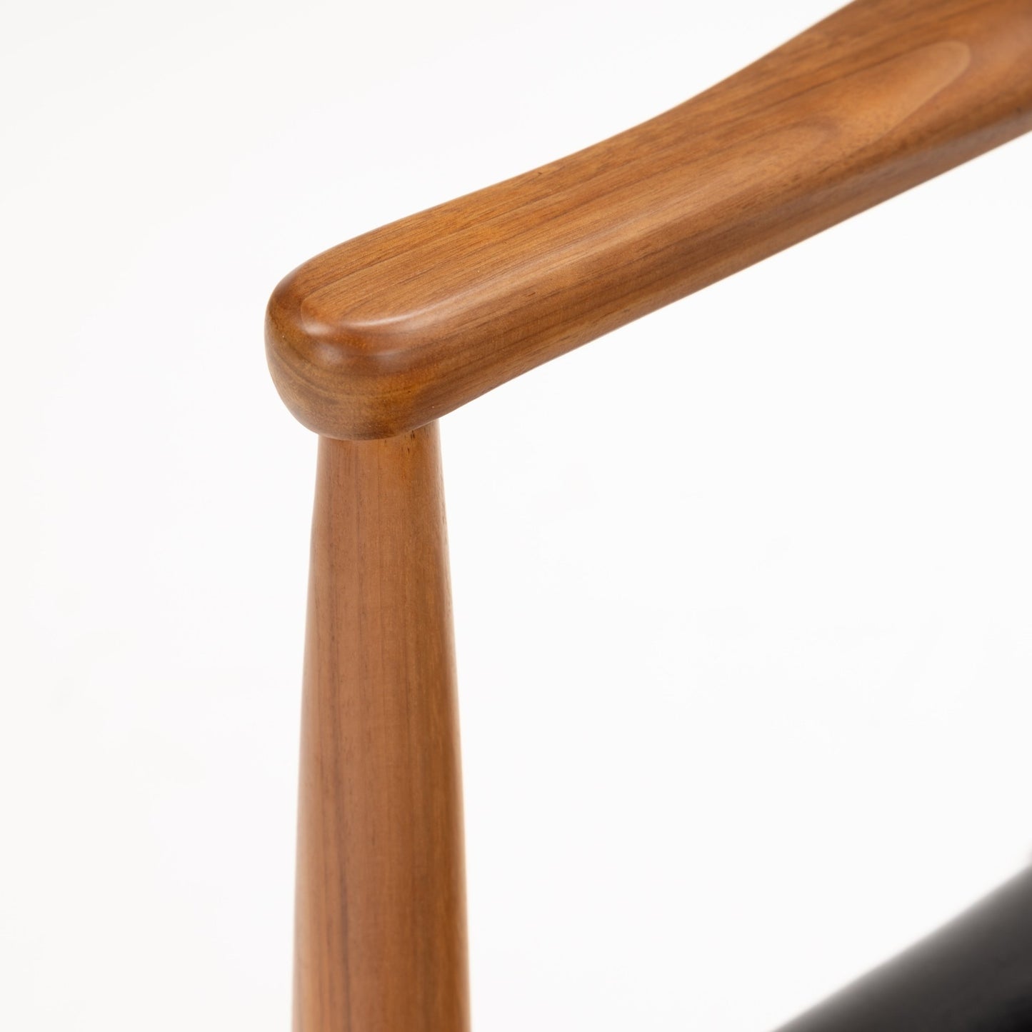 Close-up detail of sculpted walnut wood armrest and tapered leg showcasing the smooth finish and craftsmanship of the Set of 4 Walnut Dining Armchairs Attributed to Finn Juhl, highlighting mid century modern seating.