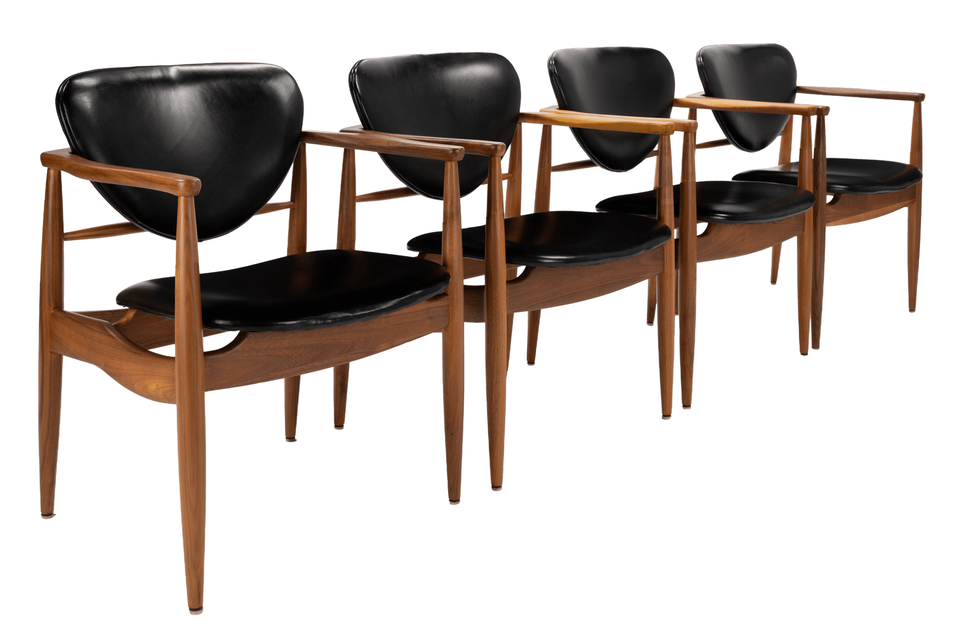 Set of 4 Walnut Dining Armchairs Attributed to Finn Juhl featuring smooth black leather upholstery and sculpted walnut frames with elegant mid century modern seating design.