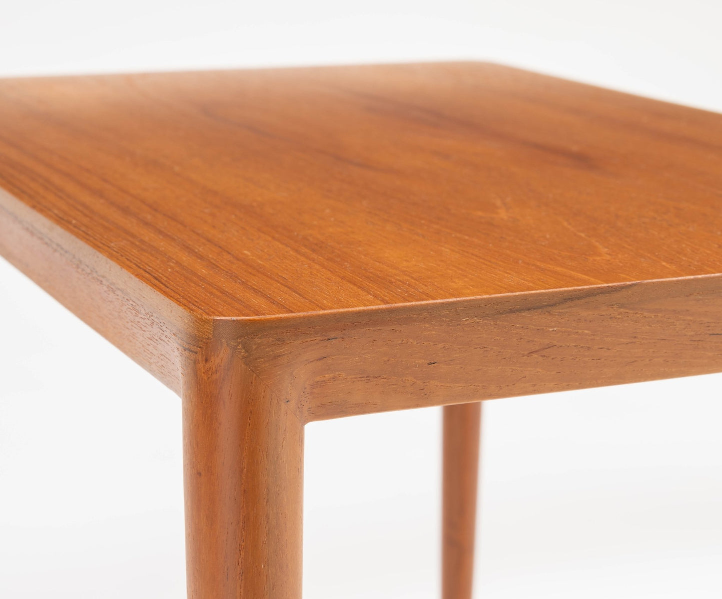 Mid-century modern teak side table with beveled edges and rounded tapered legs in the style of Severin Hansen.