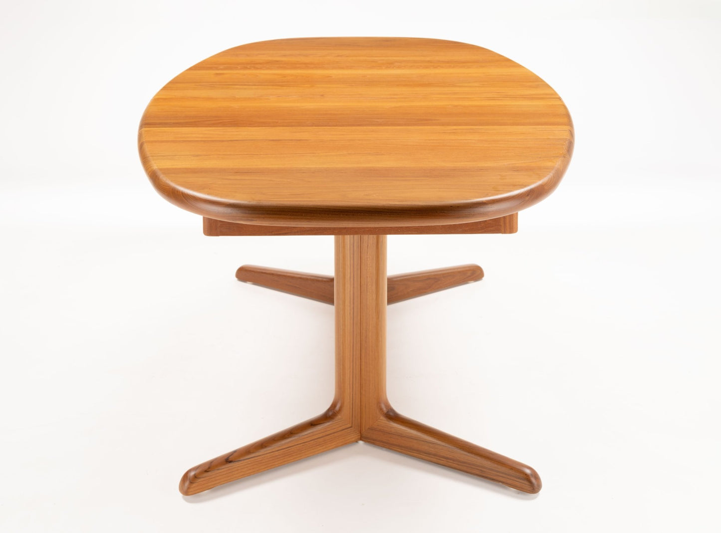 Mid-century modern Skovby teak racetrack dining table with rounded edges and central pedestal base on white background