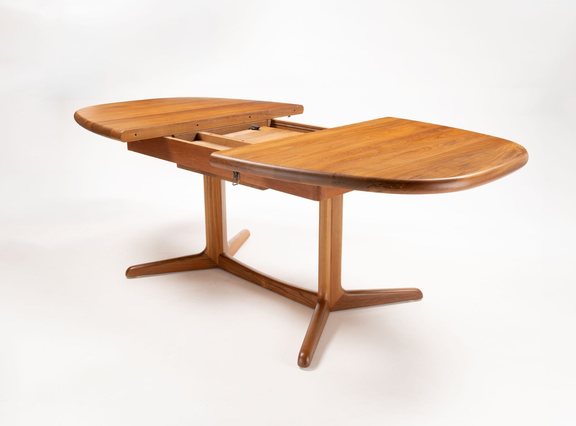 Mid-century modern Skovby teak racetrack dining table with extending leaves and rounded rectangular top on wooden base