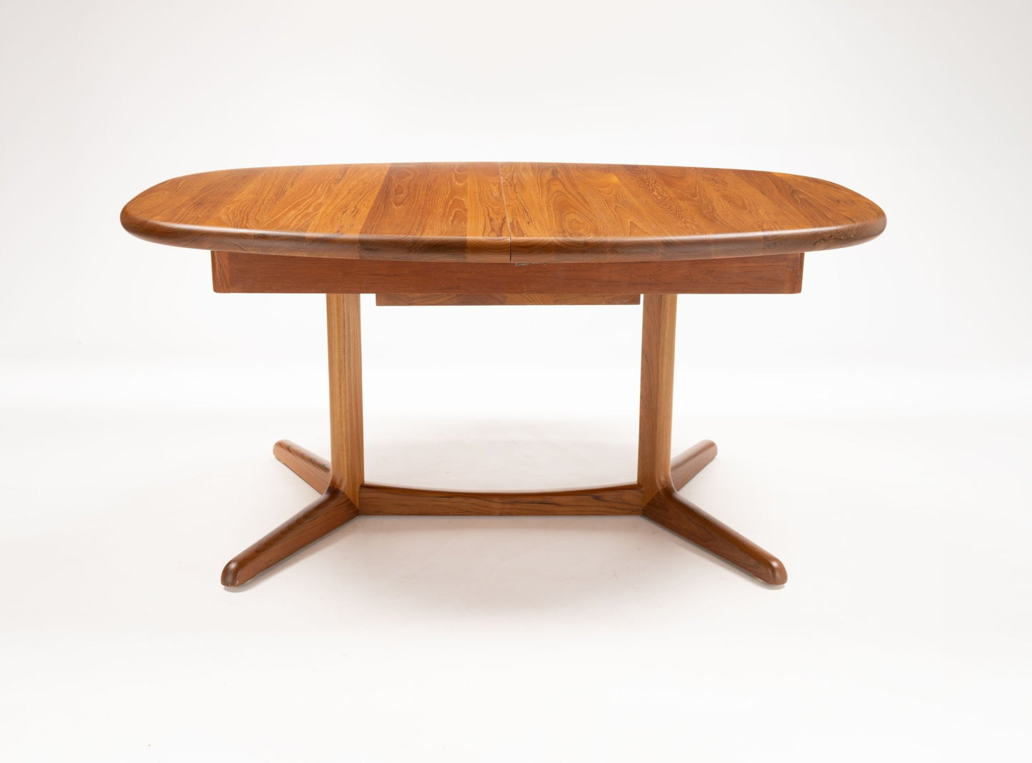 Mid-century Skovby teak racetrack dining table with rounded rectangular top and sturdy angled legs on white background