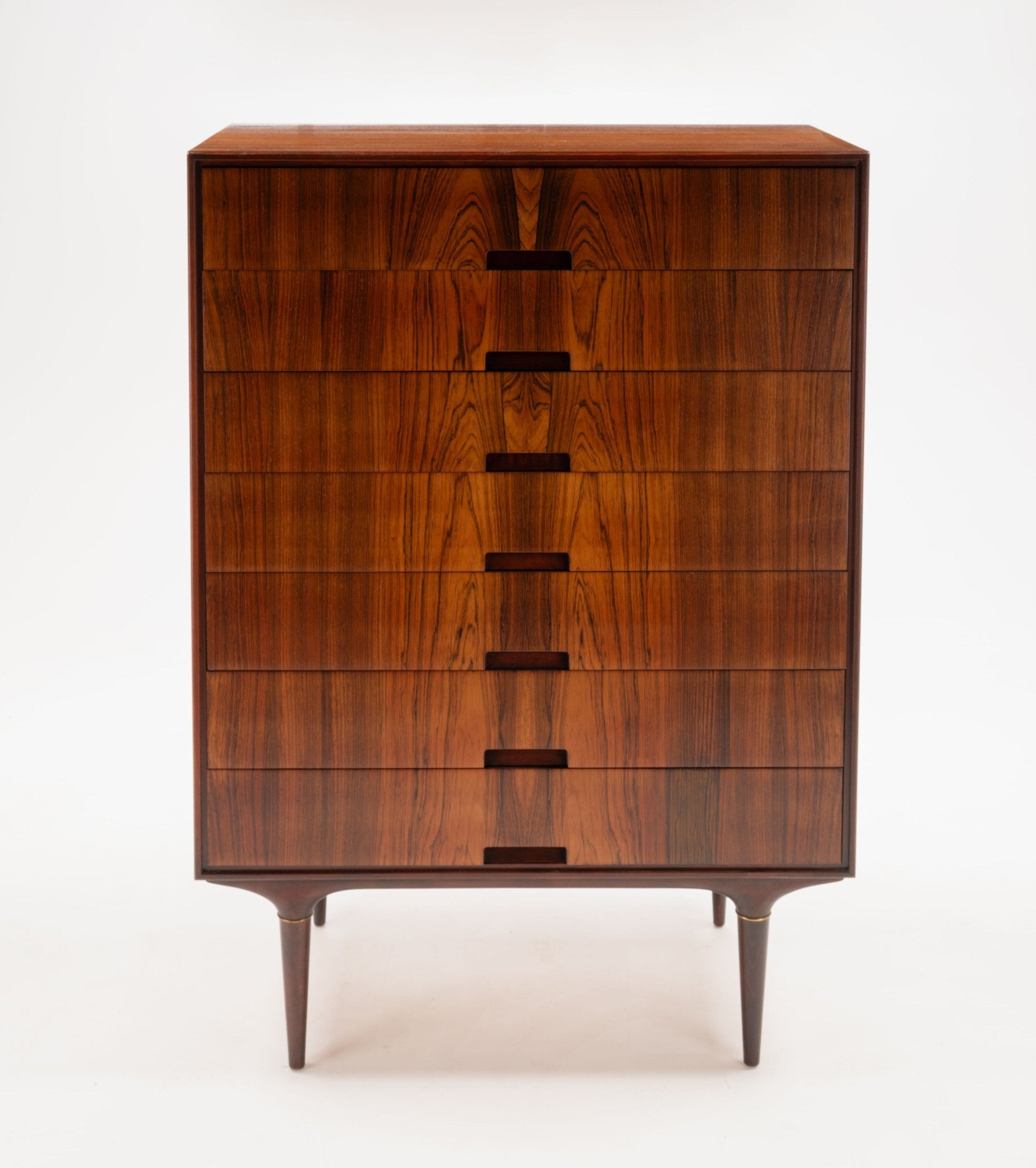 1950s Swedish rosewood dresser by Svante Skogh with bookmatched panels and brass-accented tapered legs on white background