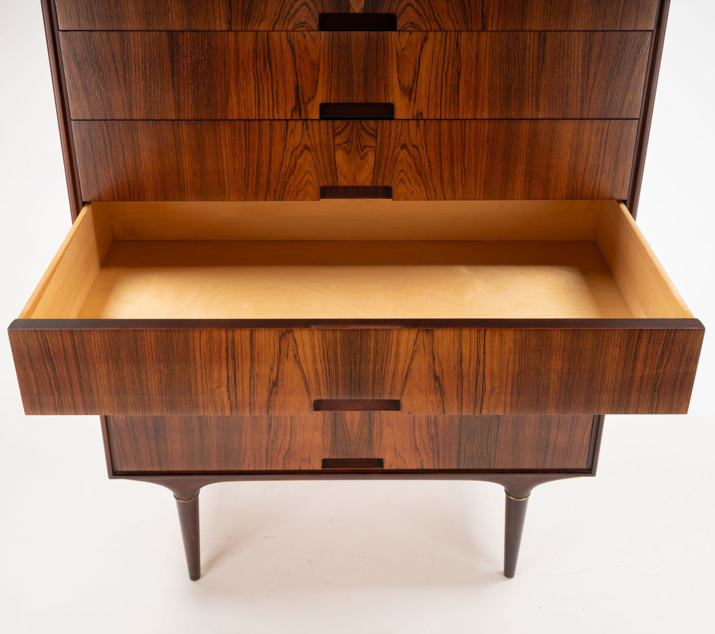 Mid-century modern rosewood dresser with open drawer, bookmatched side panels, and brass-accented tapered legs