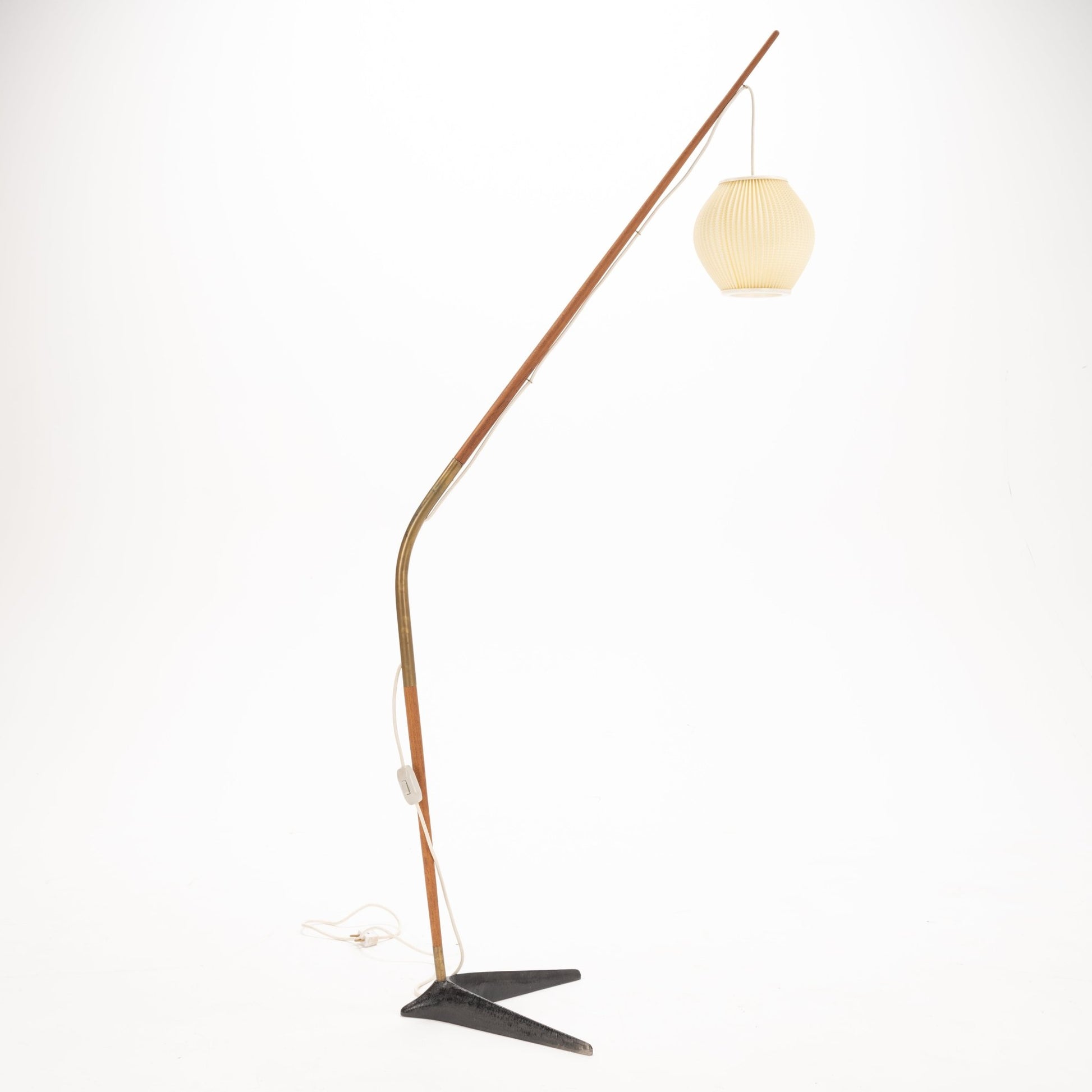 Svend Aage Holm Sorensen Floor Lamp with a slender wooden arm and brass detailing, extending in a fishing pole style to hold a pleated cream lantern shade over a minimalist black metal base, reflecting vintage Danish mid century modern lighting design.