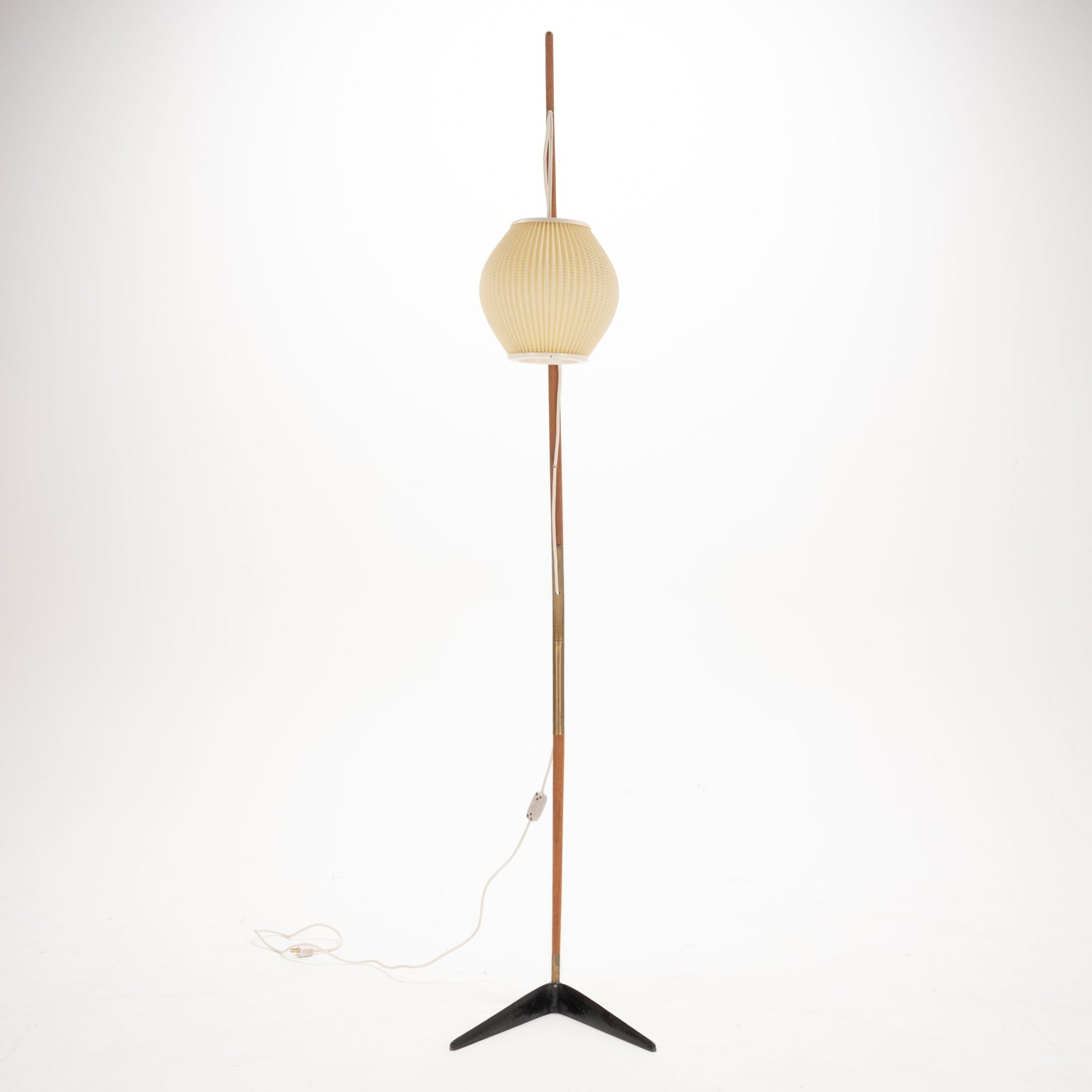Svend Aage Holm Sorensen Floor Lamp with a tall, slender wooden pole and brass details, featuring a softly ribbed cream paper lantern shade and resting on a minimalist black metal tripod base, reflecting vintage Danish mid century modern lighting design.