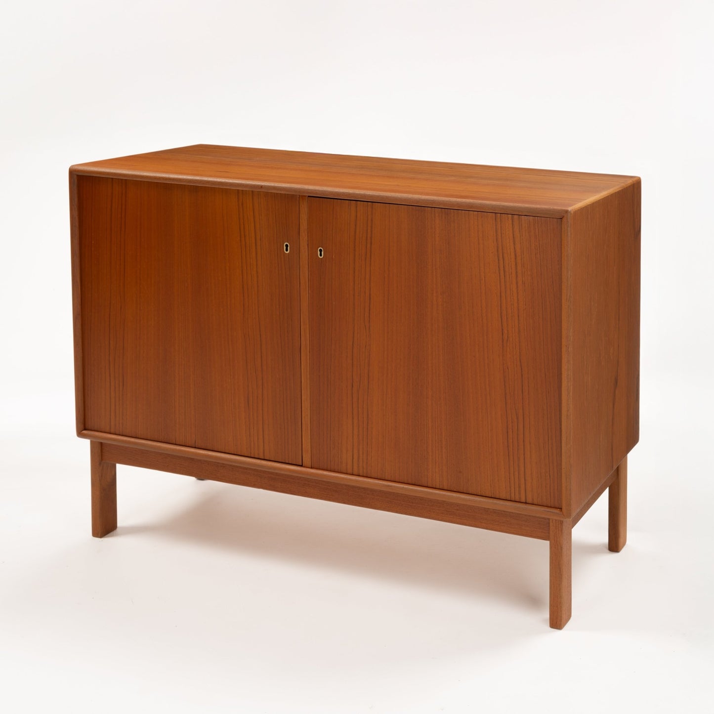 Swedish Teak Cabinet & Bookcase - Set 1 featuring a minimalist teak storage unit with two closed doors, showcasing clean lines and a warm wood finish in mid century modern style.