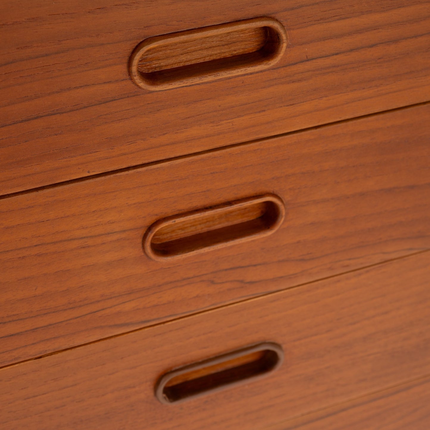 Swedish Teak Cabinet & Bookcase - Set 2 featuring close-up of smooth teak wood drawer fronts with integrated recessed oval handles, showcasing vintage Danish mid century modern storage craftsmanship.