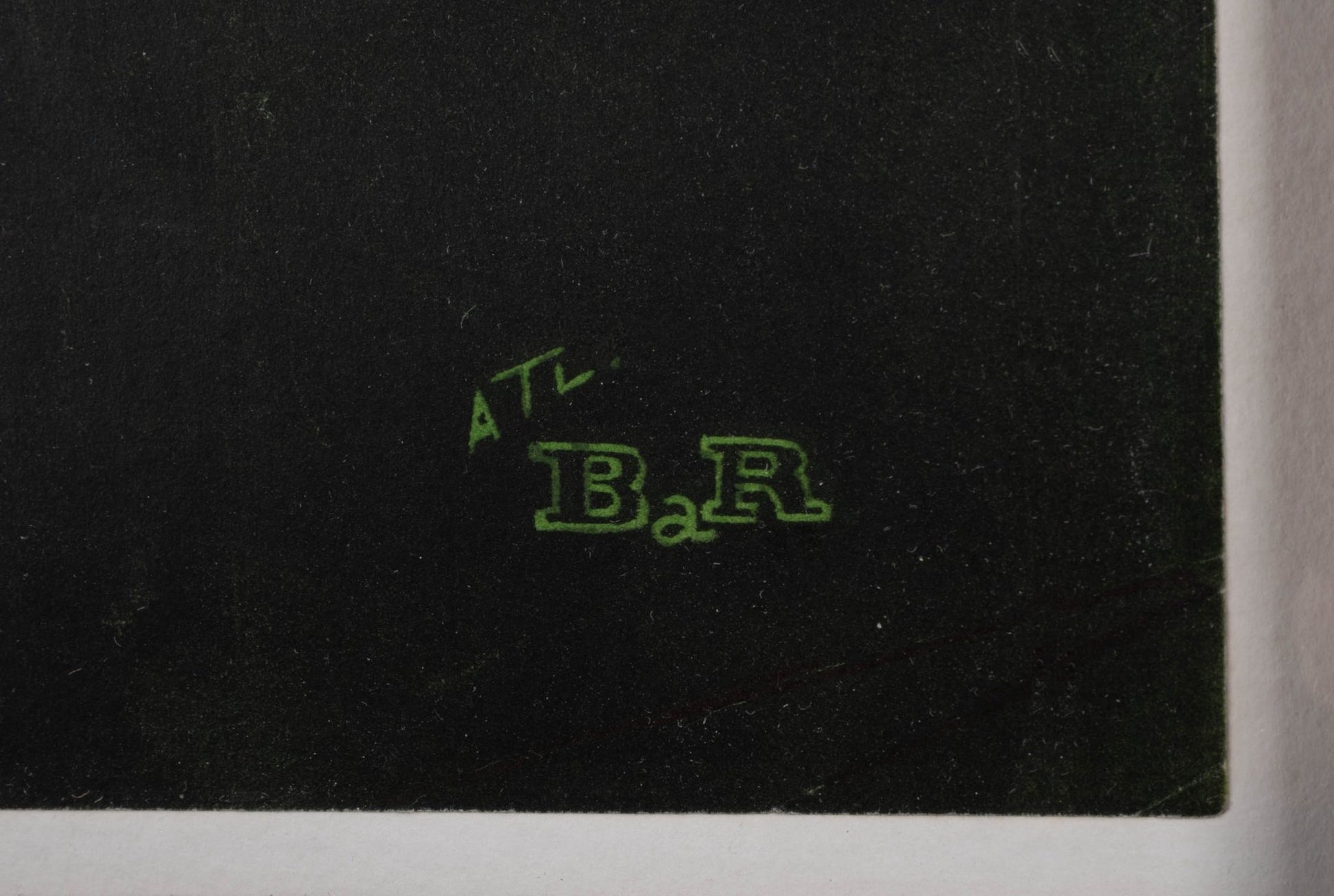 Close-up of green printed signature detail on black linen-backed vintage travel poster corner.