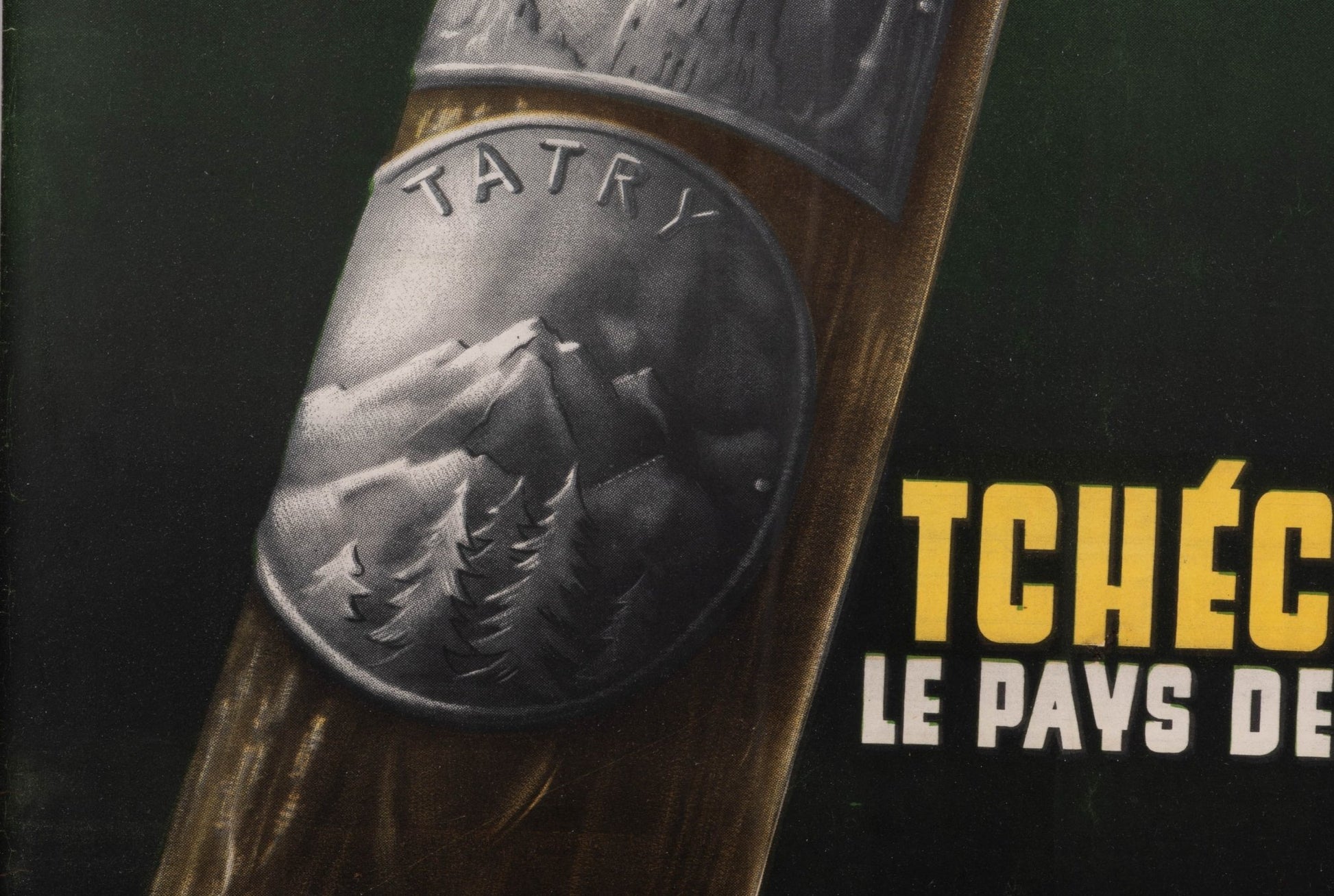 Close-up of vintage Tchecoslovaquie travel poster featuring metal Tatry mountain emblem on wooden background