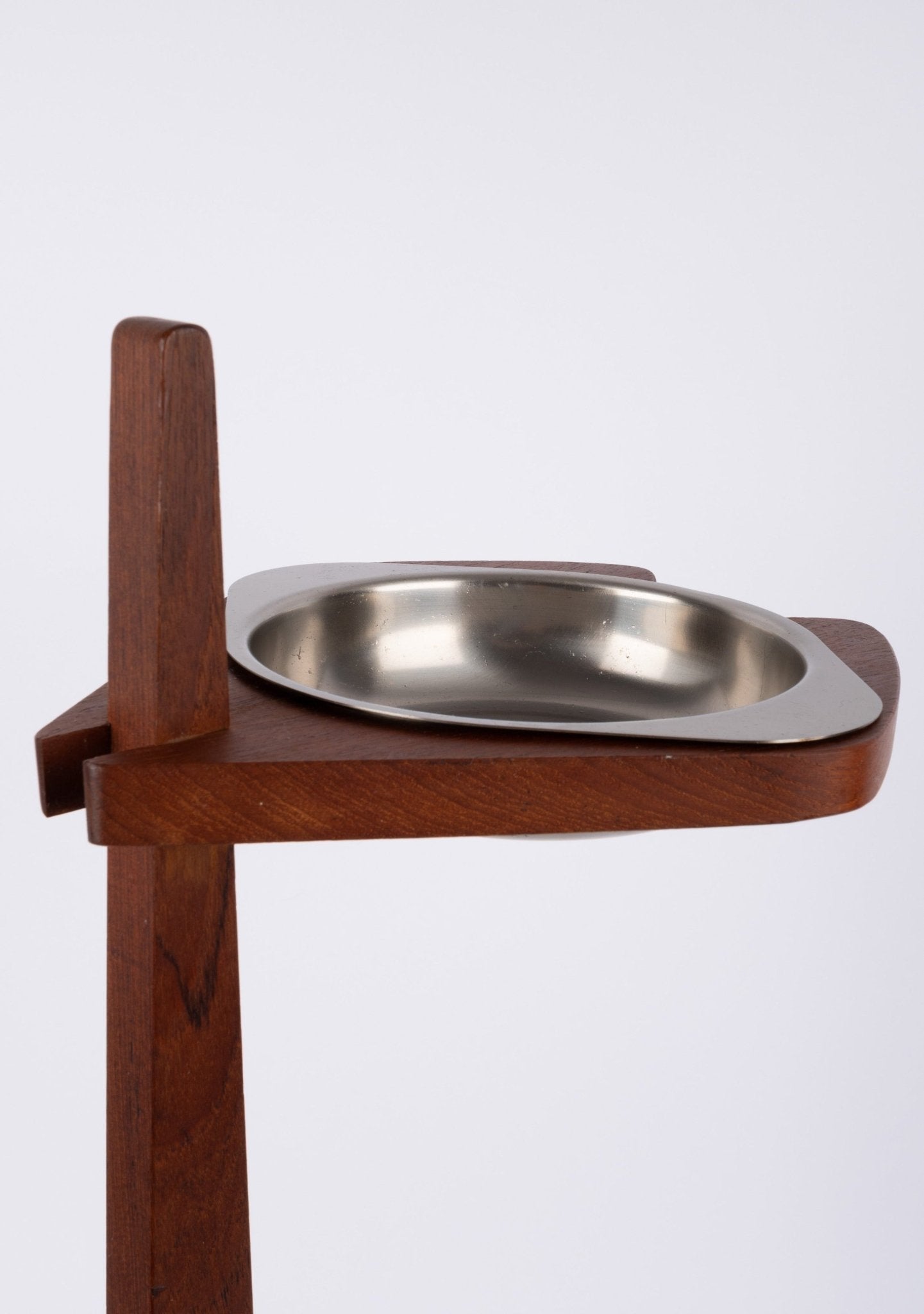 Teak ashtray stand with tapered stem and stylized base featuring a floating metal ashtray bowl from the mid-century era