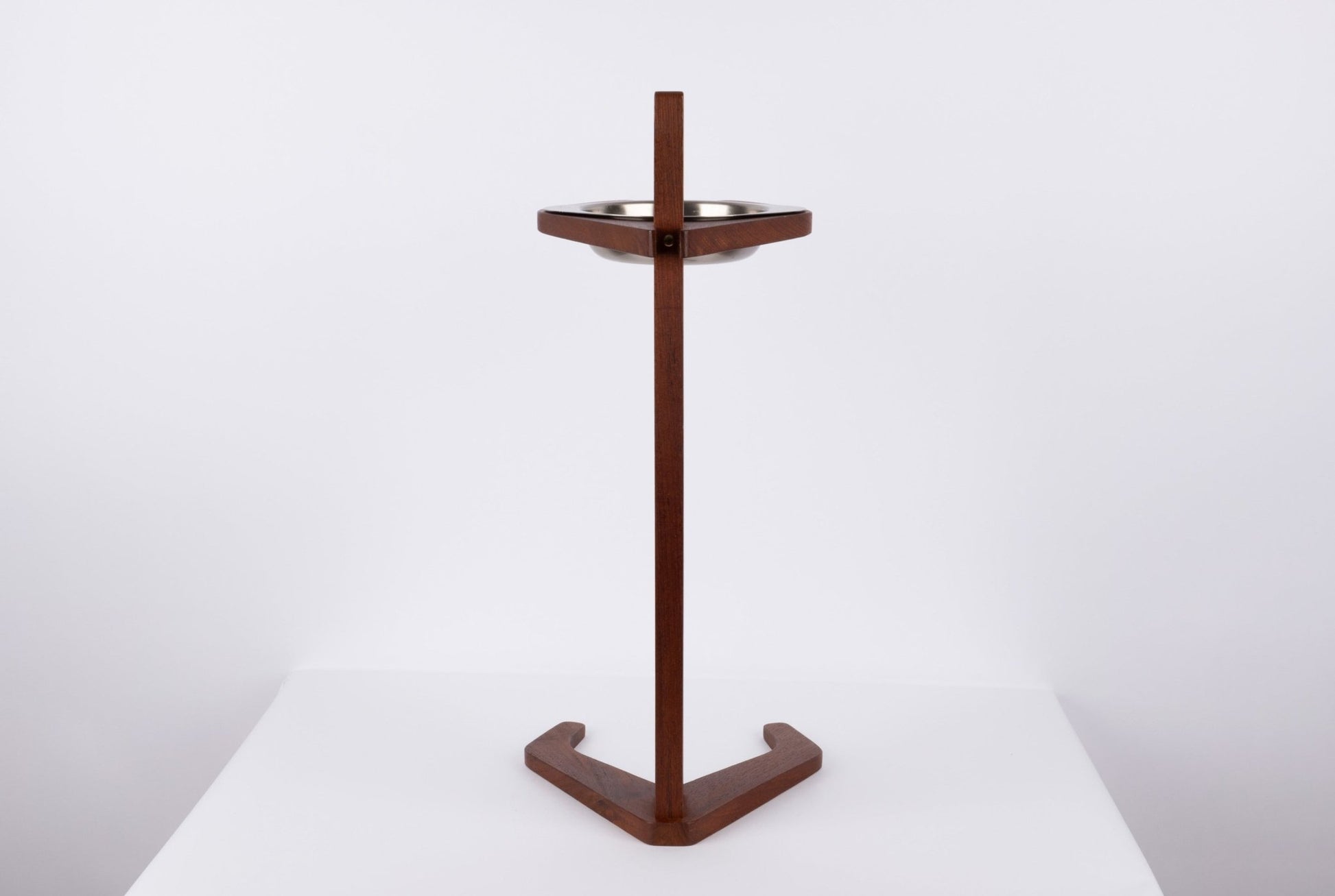 Teak ashtray stand with metal bowl featuring a tapered stem and stylized triangular base on a white background.