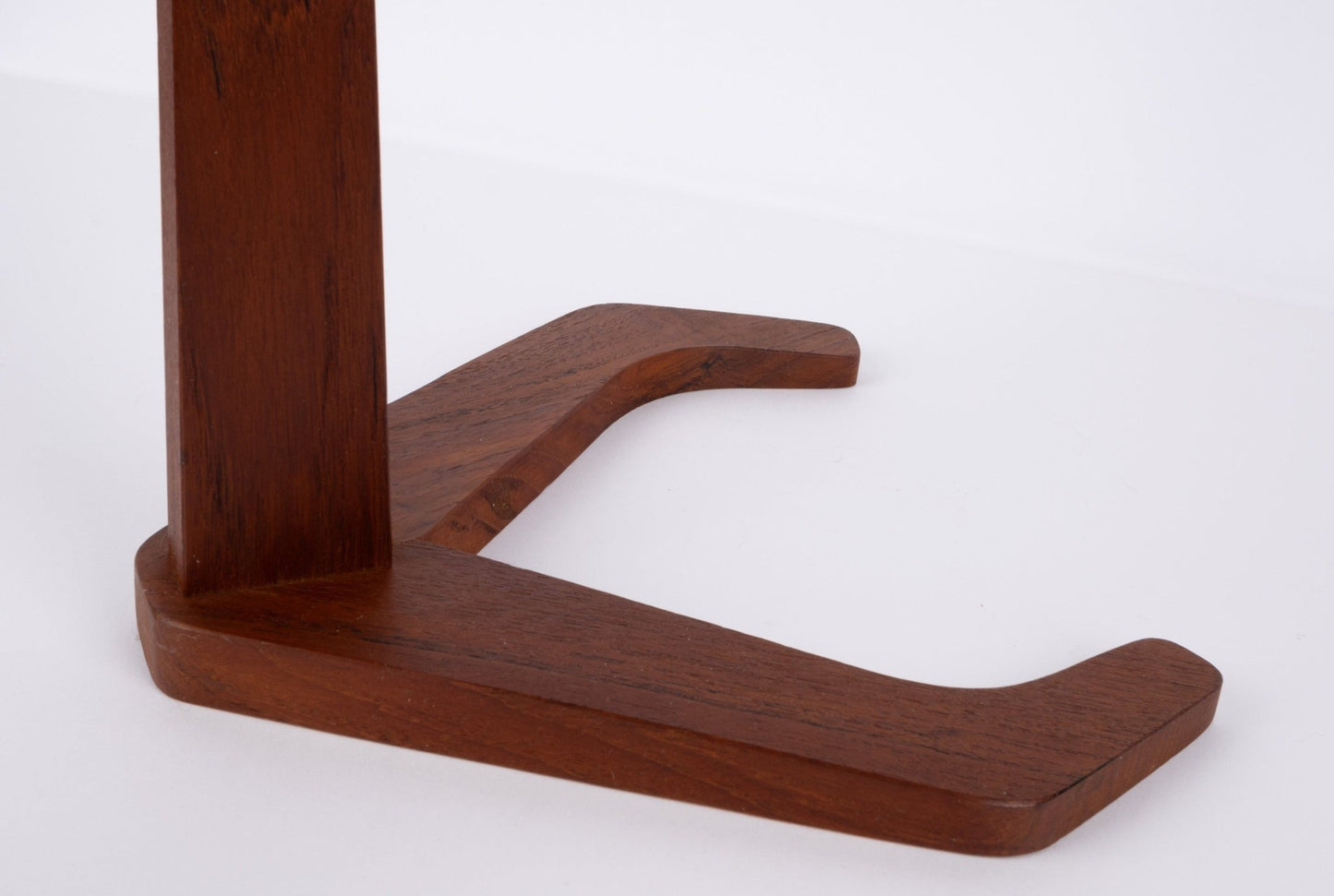 Close-up of tapered teak base and stylized frame detail from a mid-century teak ashtray stand.