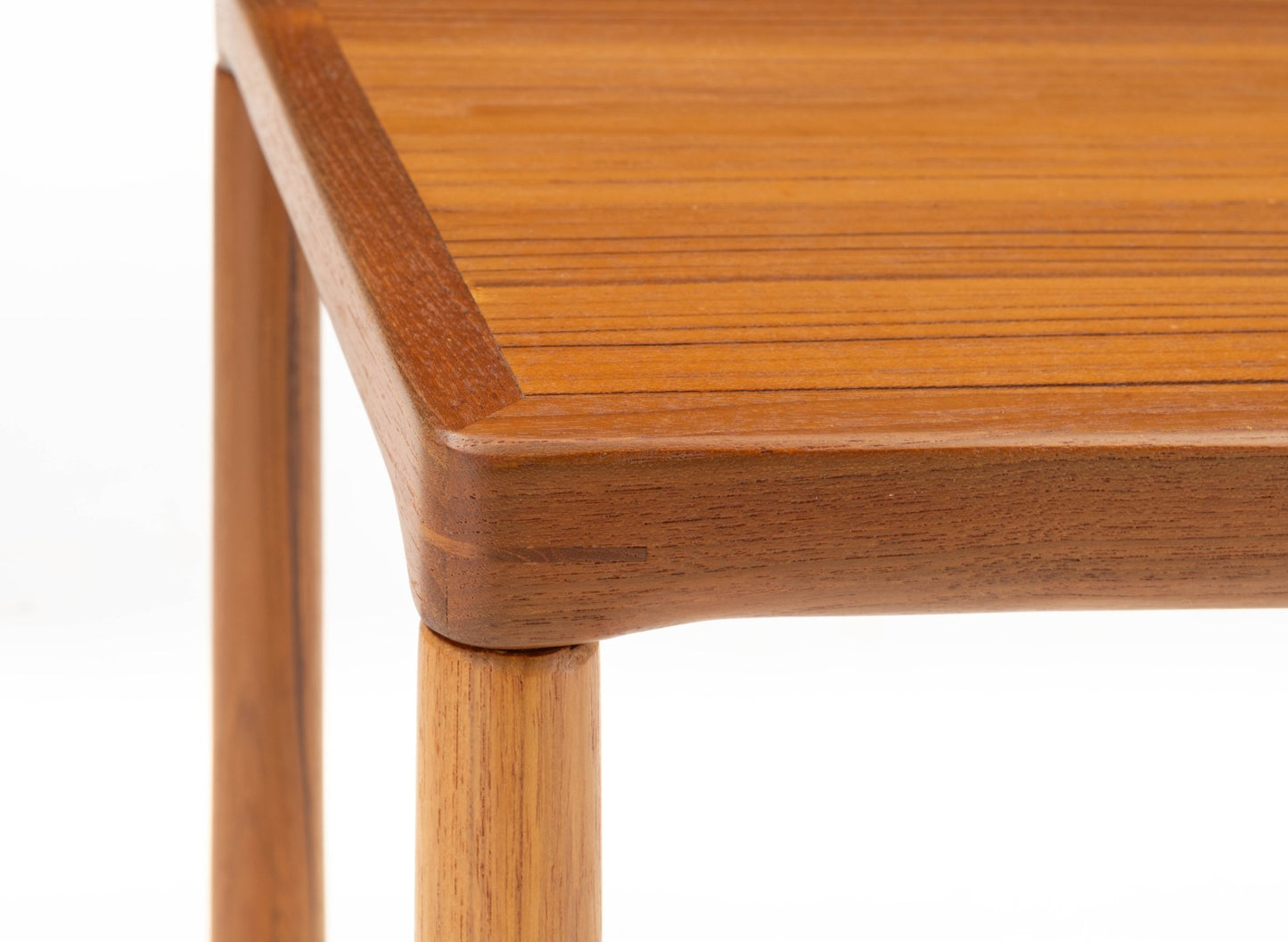 Close-up of teak side table corner with finger joint detail and oak tapered leg in mid-century modern style
