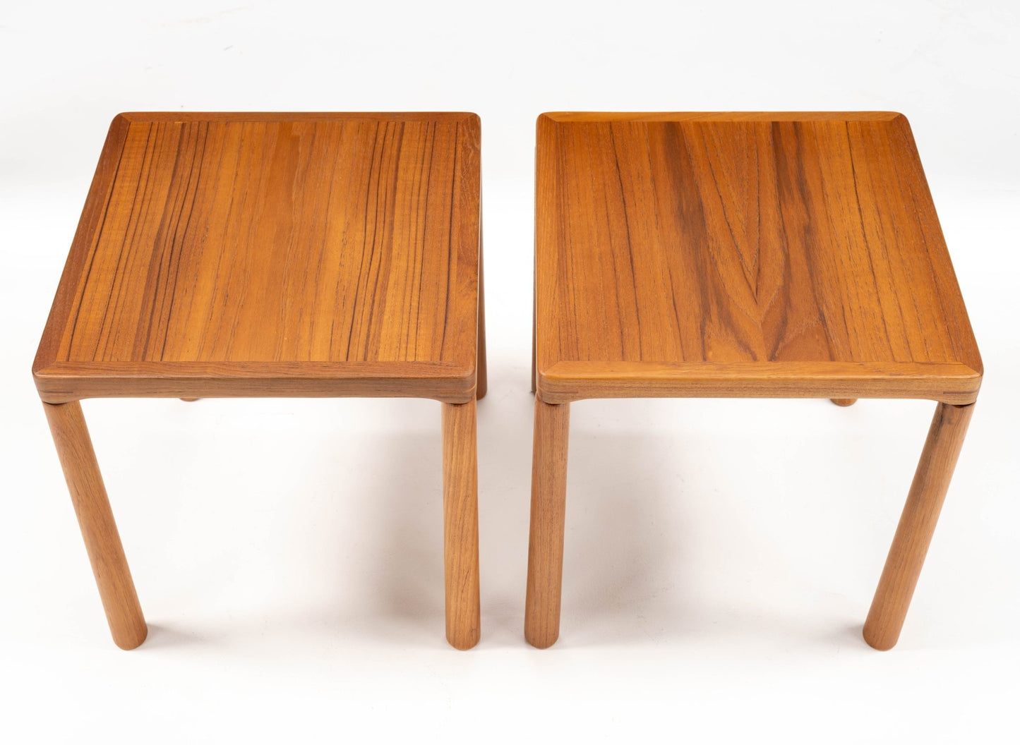 Pair of mid-century modern teak side tables with oak legs and finger joint details on top corners against white background