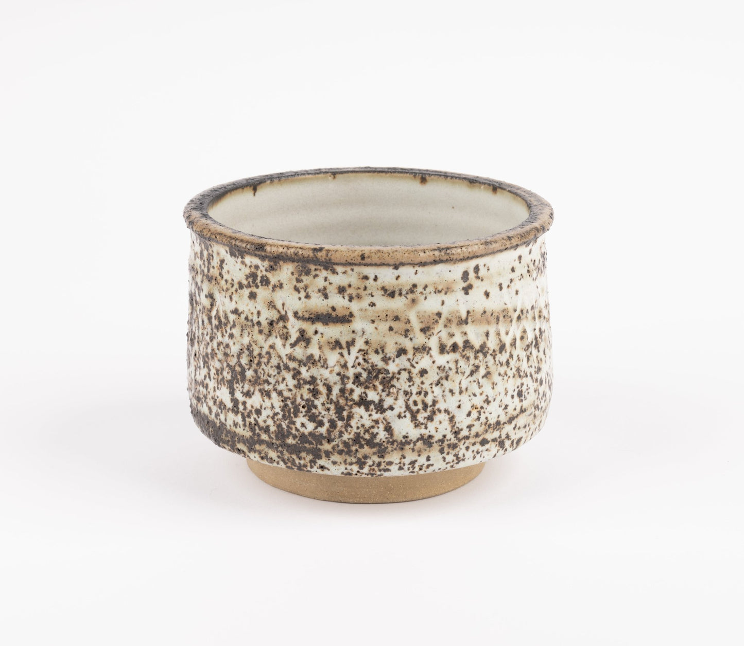 Tessa Kidick studio pottery bowl with low cylindrical form, raised foot, and mottled ivory, charcoal, and brown glaze
