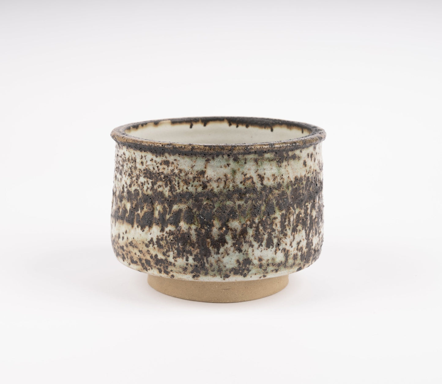 Tessa Kidick studio pottery bowl with low cylindrical form, raised foot, and mottled ivory, charcoal, and brown glaze finish