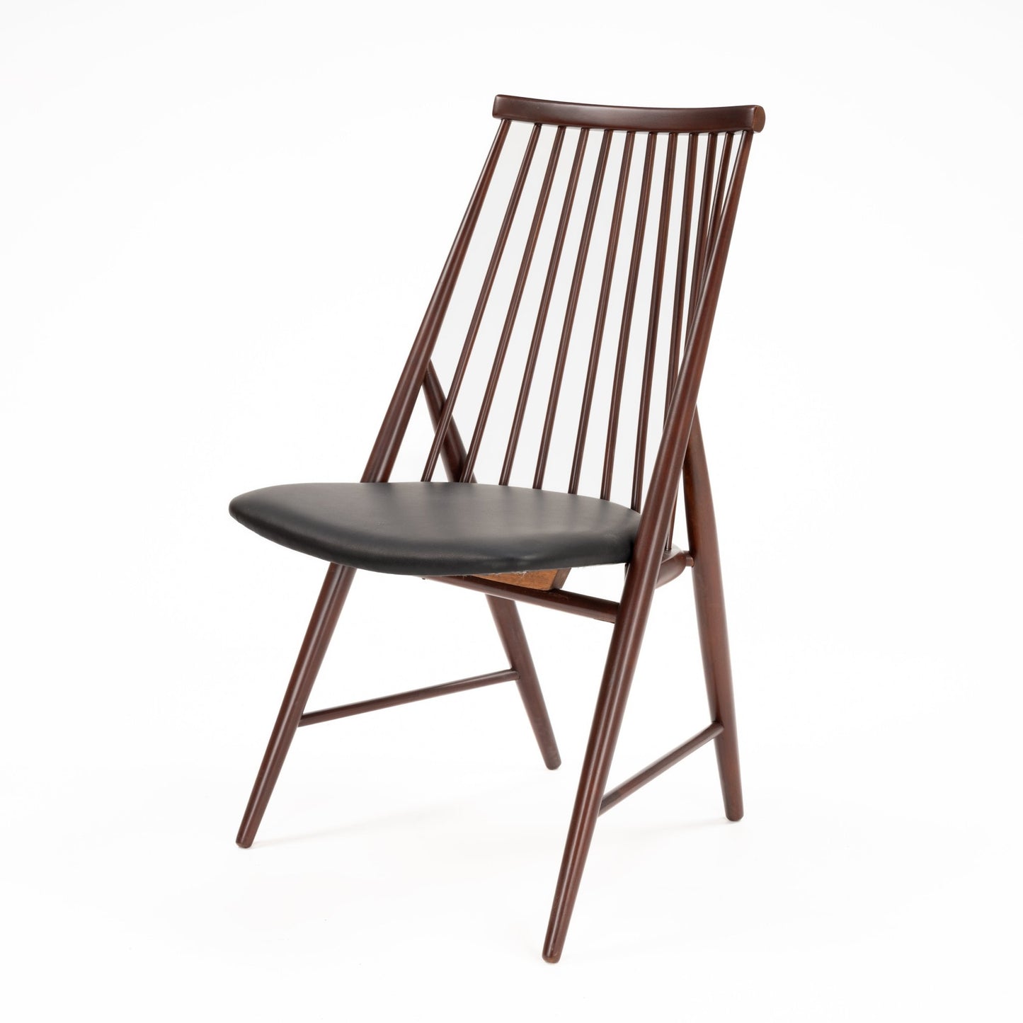 Angled view of wooden chair with a tall spindle backrest and black cushioned seat in dark brown finish