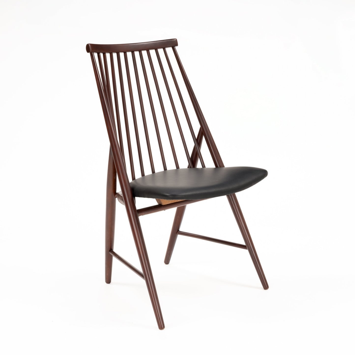 Profile view of sleek wooden chair with tall angled spindle backrest and black leather padded seat
