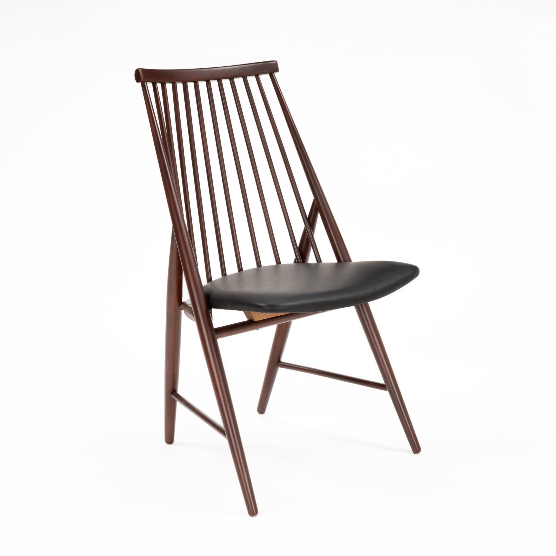 Profile view of sleek wooden chair with tall angled spindle backrest and black leather padded seat