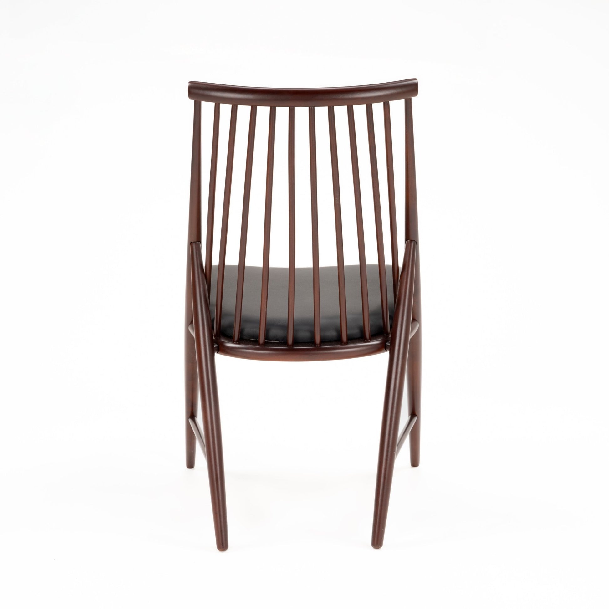 Rear view of slender wooden chair with multiple vertical spindles and black cushioned seat in dark finish
