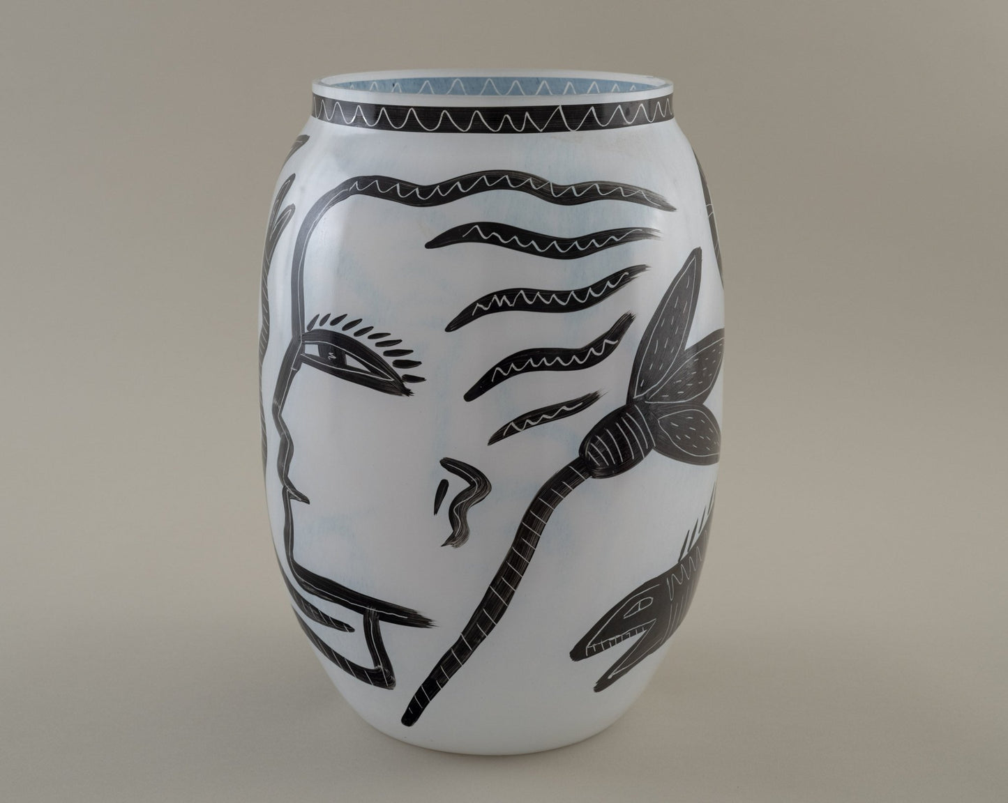 Ulrica Hydman-Vallien "Caramba" vase for Kosta Boda with black hand-painted faces, serpents, and flora motifs on white glass