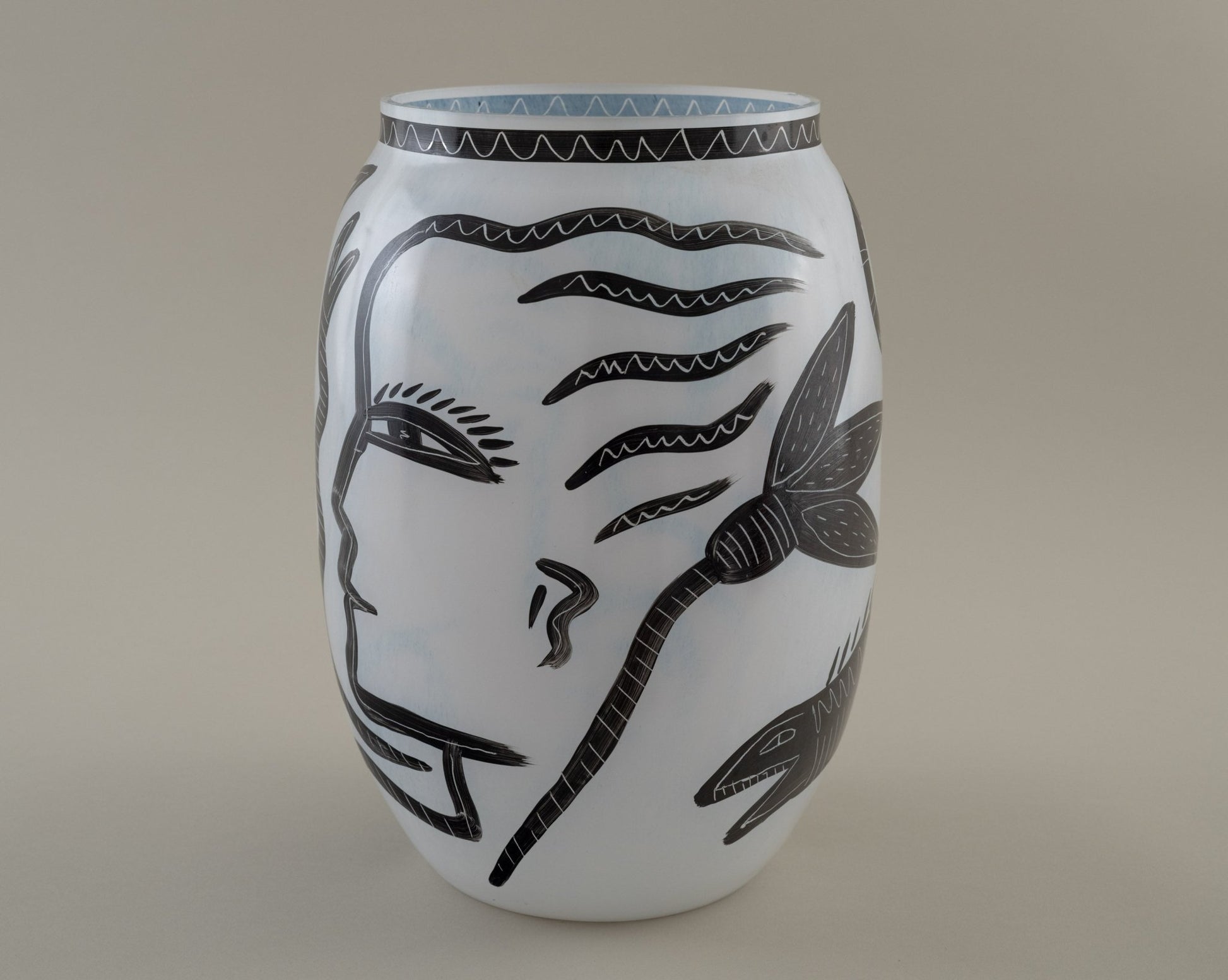 Ulrica Hydman-Vallien "Caramba" vase for Kosta Boda with black hand-painted faces, serpents, and flora motifs on white glass