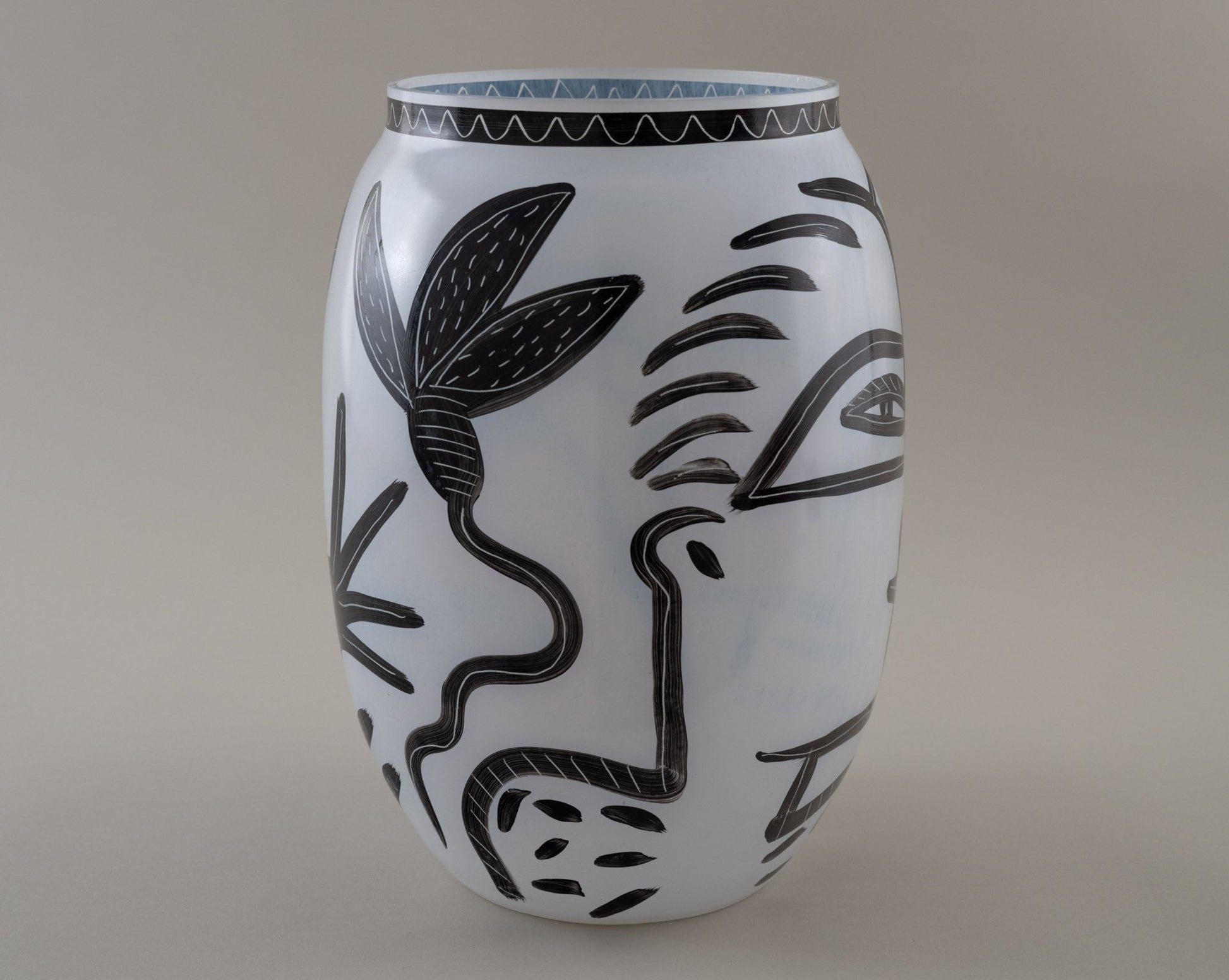 Ulrica Hydman-Vallien "Caramba" vase for Kosta Boda with black hand-painted faces, snakes, and floral motifs on white glass