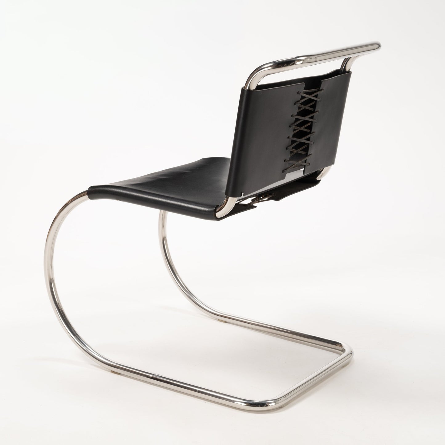 Rear angle of Van Der Rohe MR10 cantilever chair with polished chrome tubular frame and black leather laced backrest