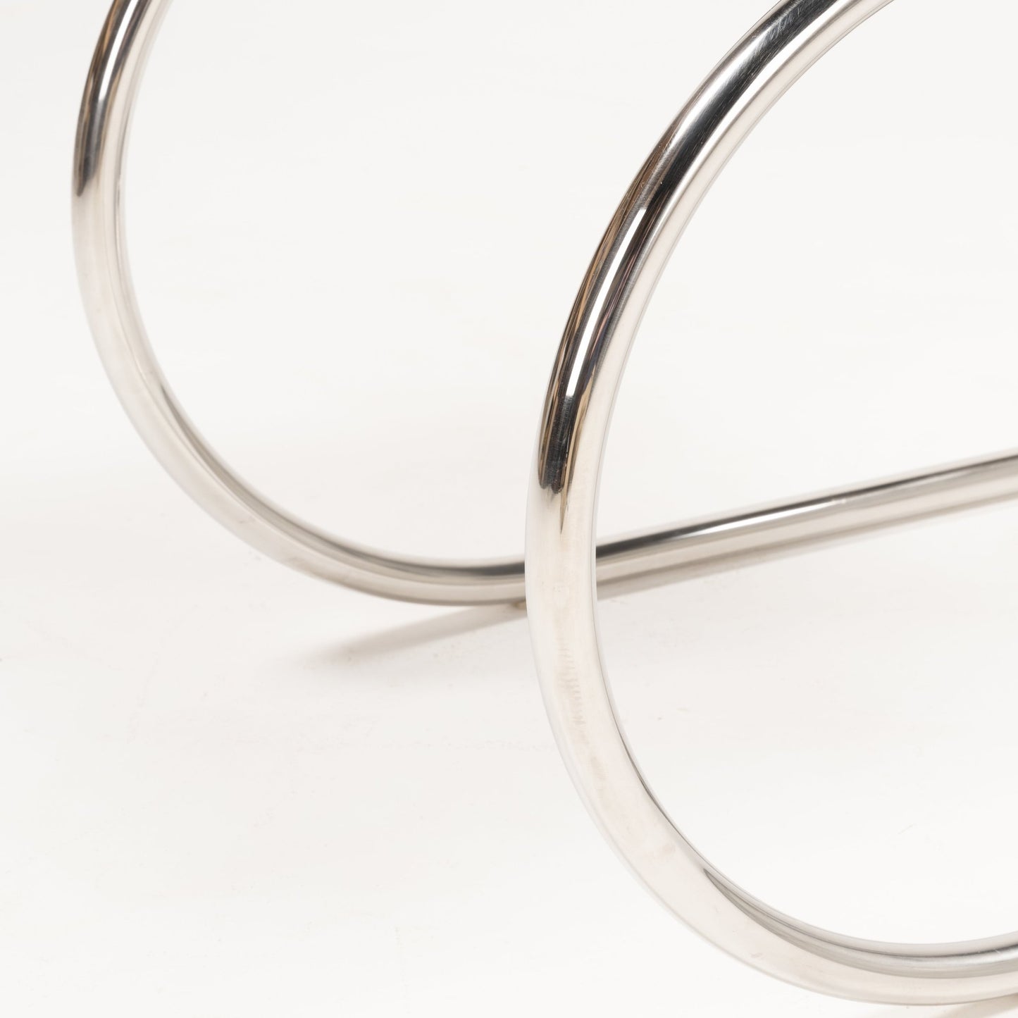 Close-up of polished chrome tubular steel frame detail on the base of Van Der Rohe MR10 cantilever chair
