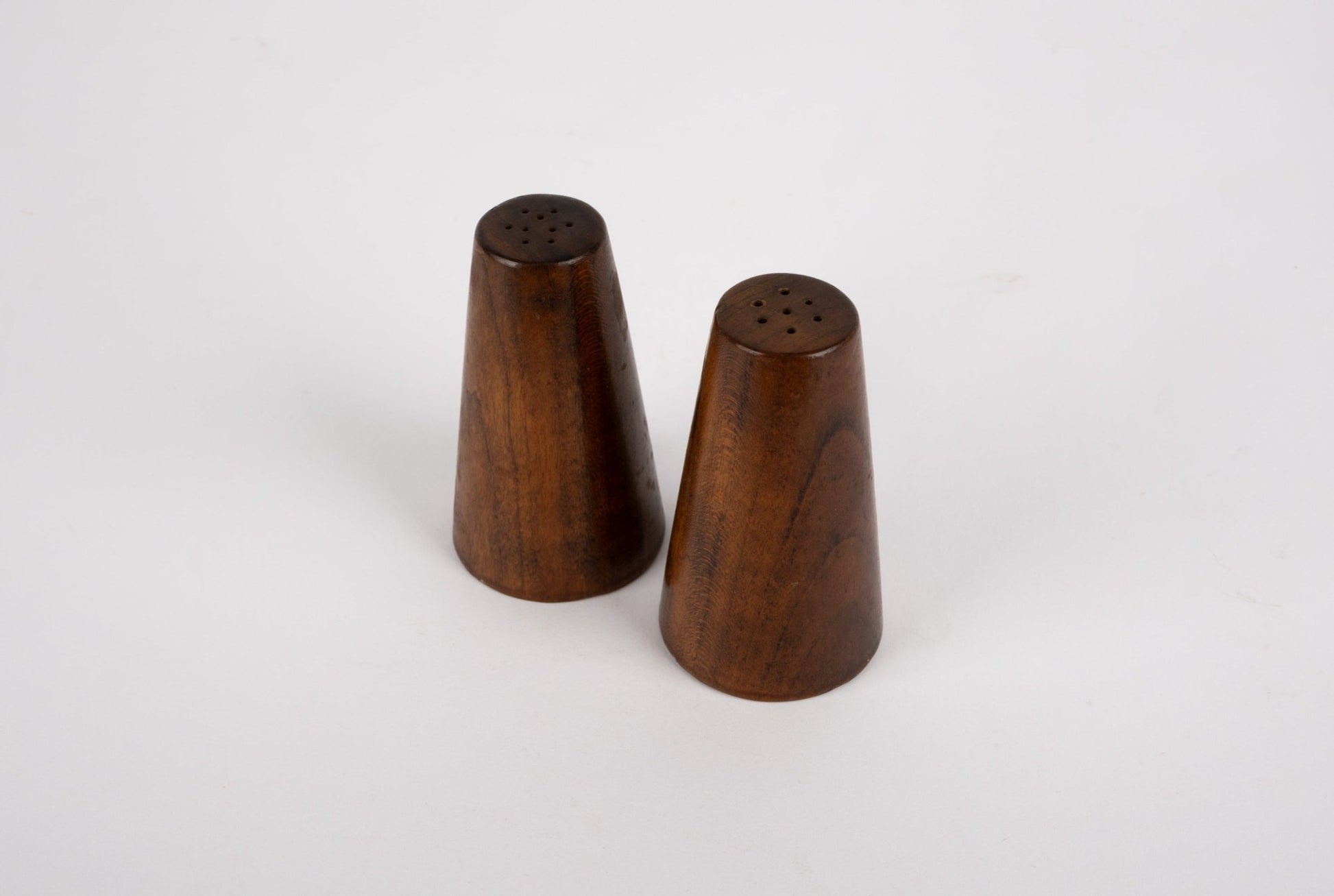 Pair of tapered solid walnut salt and pepper shakers inspired by Paul Evans and Phil Powell with a mid-century modern style