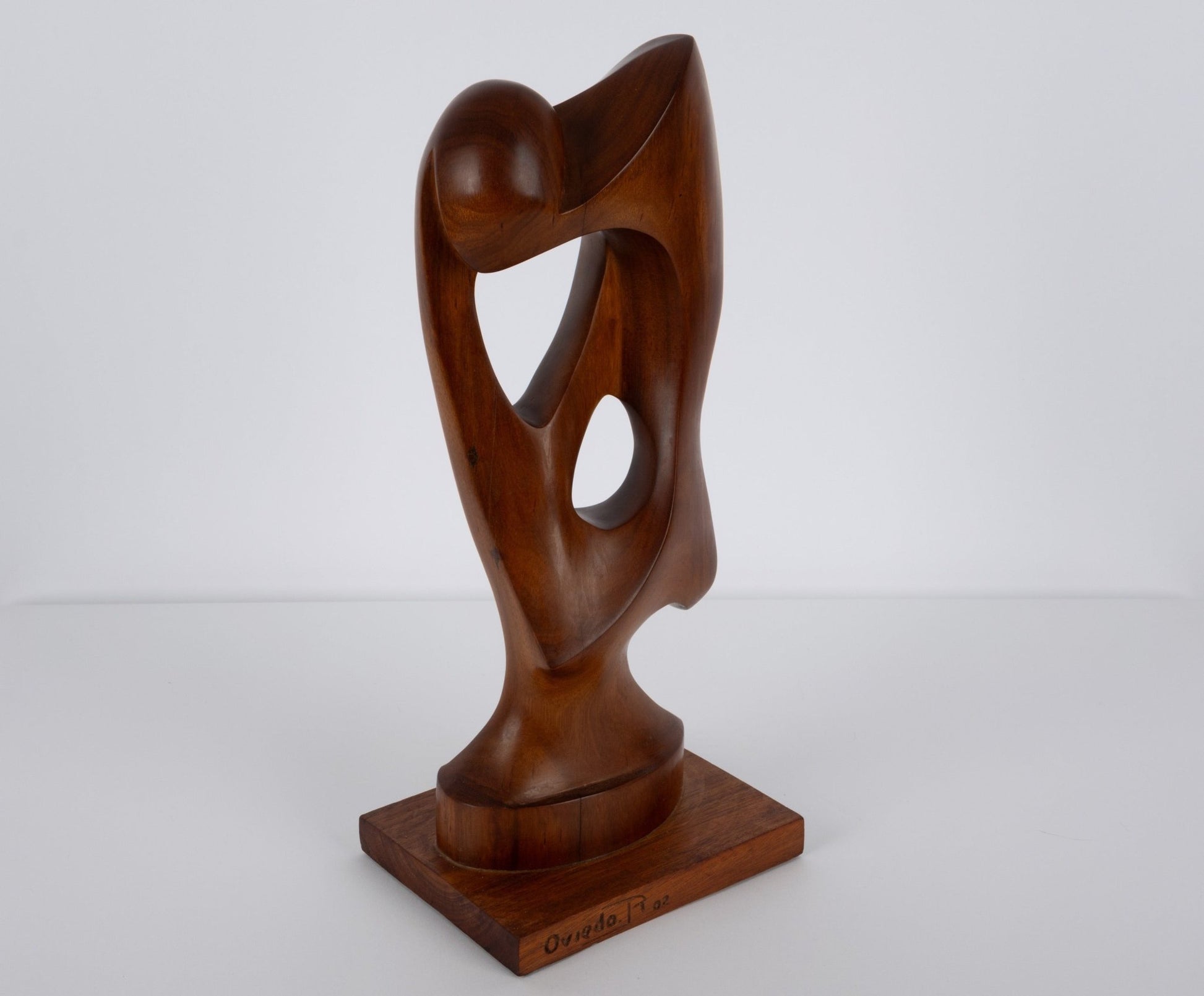 Abstract mid-century modern sculpture carved from solid walnut with smooth organic curves on wooden base
