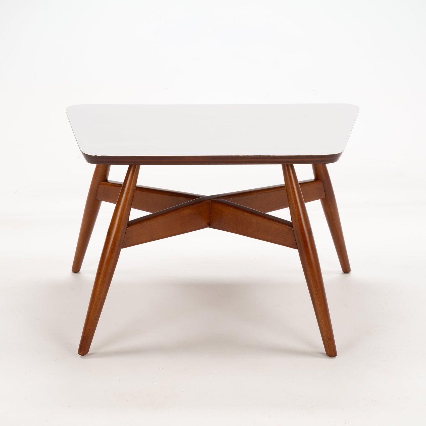 Walnut Side Table with Laminate Top featuring a clean white rectangular surface supported by slender tapered walnut legs with crossbeam supports, embodying mid century modern style.