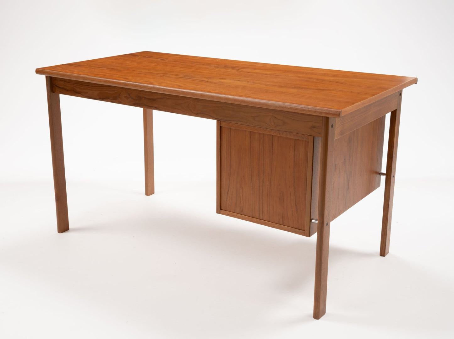 Mid-century modern teak writing desk by Peter Lovig Nielsen with sliding top and three drawers, showcasing Danish design.