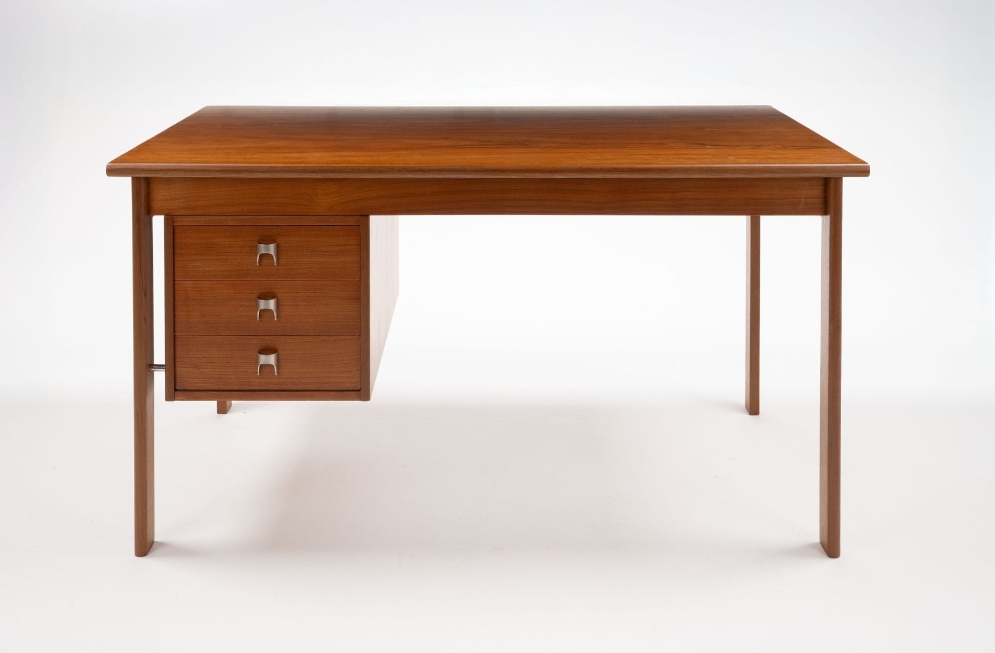 Mid-century modern teak writing desk by Peter Lovig Nielsen with sliding top, three drawers, and stainless steel handles.