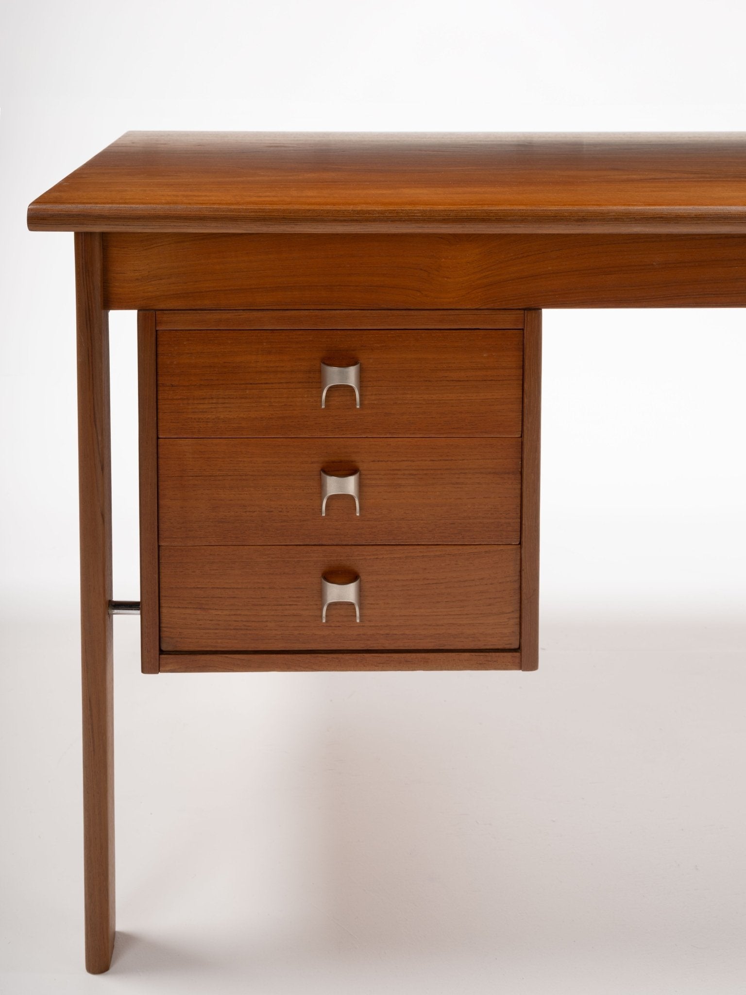 Mid-century modern teak writing desk with three drawers and sculpted stainless steel handles by Peter Lovig Nielsen.